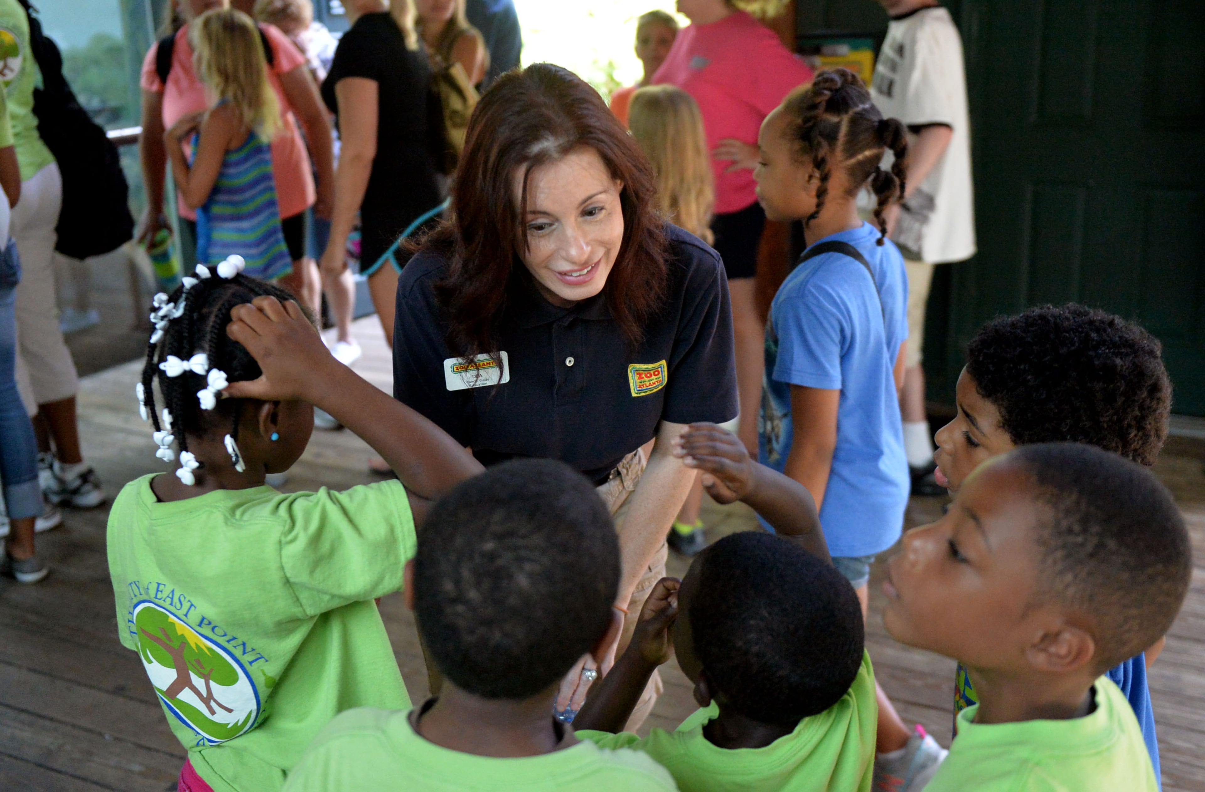 Panda guide Dee Gorman talks with summer camp visitors to the panda enclosure. Giant panda twins Mei Lun (top) and Mei Huan rest in their enclosure at Zoo Atlanta, Wednesday, July 9, 2014. Born at 6:21 p.m. and 6:23 p.m. on the evening of July 15, 2013, Mei Lun and Mei Huan were the first giant pandas born in the U.S. in 2013 and are the only pair of surviving giant panda twins ever born in the U.S. The cubs are the fourth and fifth offspring of Lun Lun and Yang Yang; their older brothers, Mei Lan and Xi Lan, and older sister, Po, now reside at China's Chengdu Research Base of Giant Panda Breeding.