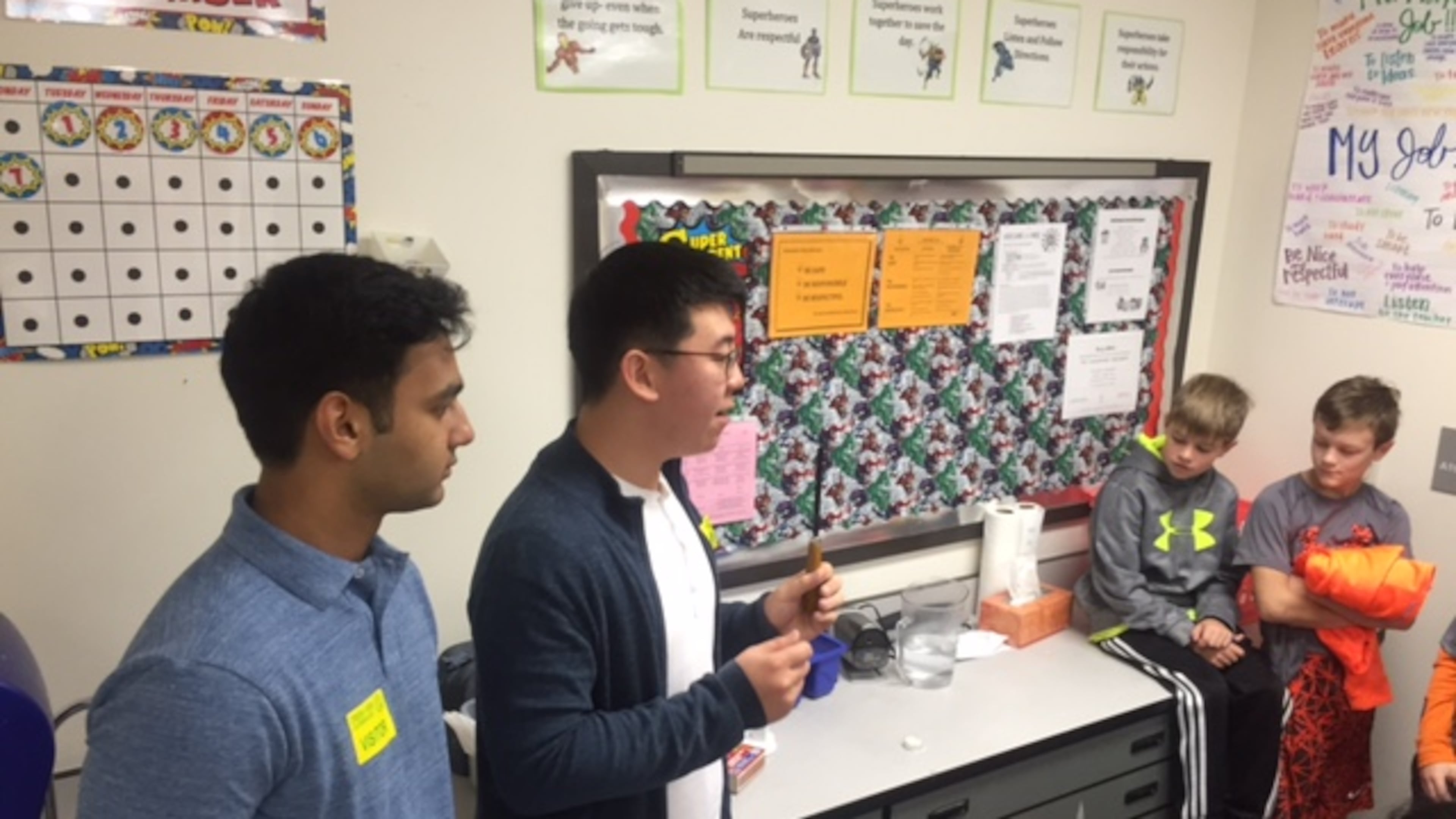 Alpharetta High School students teach a science lesson to Creek View students Matthew Kloecker and Wesley Austin, from Adrienne Hunter’s fourth-grade class.