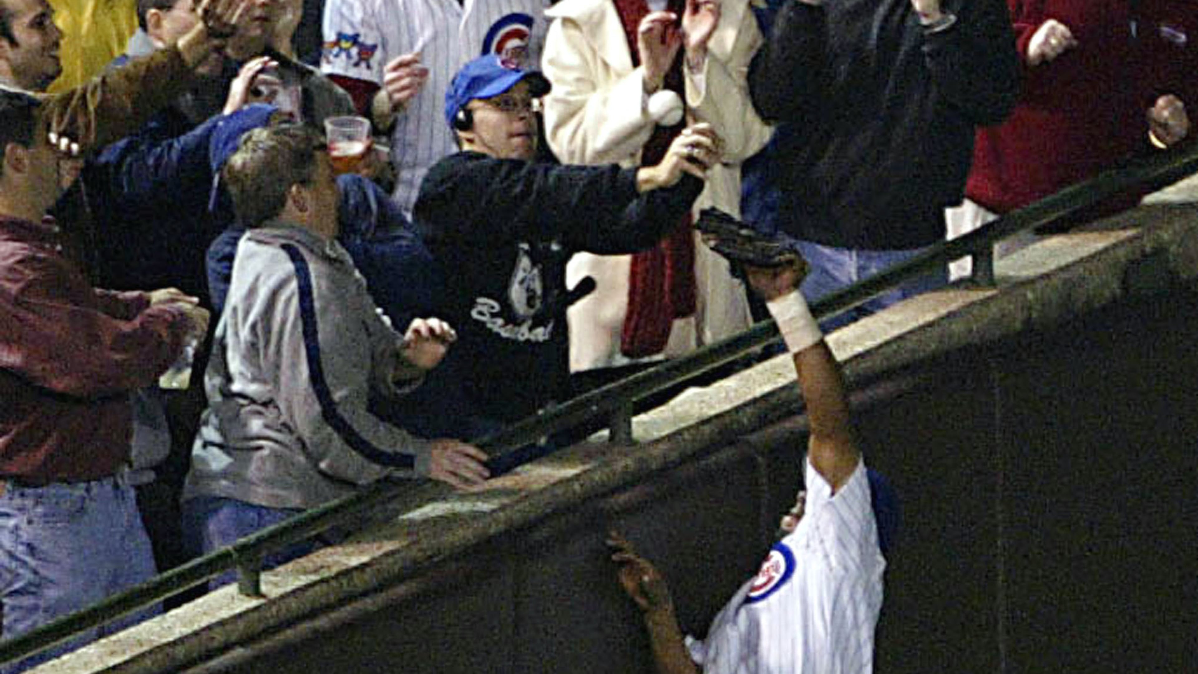 CHICAGO - OCTOBER 14: Fans interfere with outfielder Moises Alou #18 of the Chicago Cubs on a ball hit by Luis Castillo #1 of the Florida Marlins in the eighth inning during Game 6 of the National League Championship Series October 14, 2003 at Wrigley Field in Chicago, Illinois. (Photo by Elsa/Getty Images)