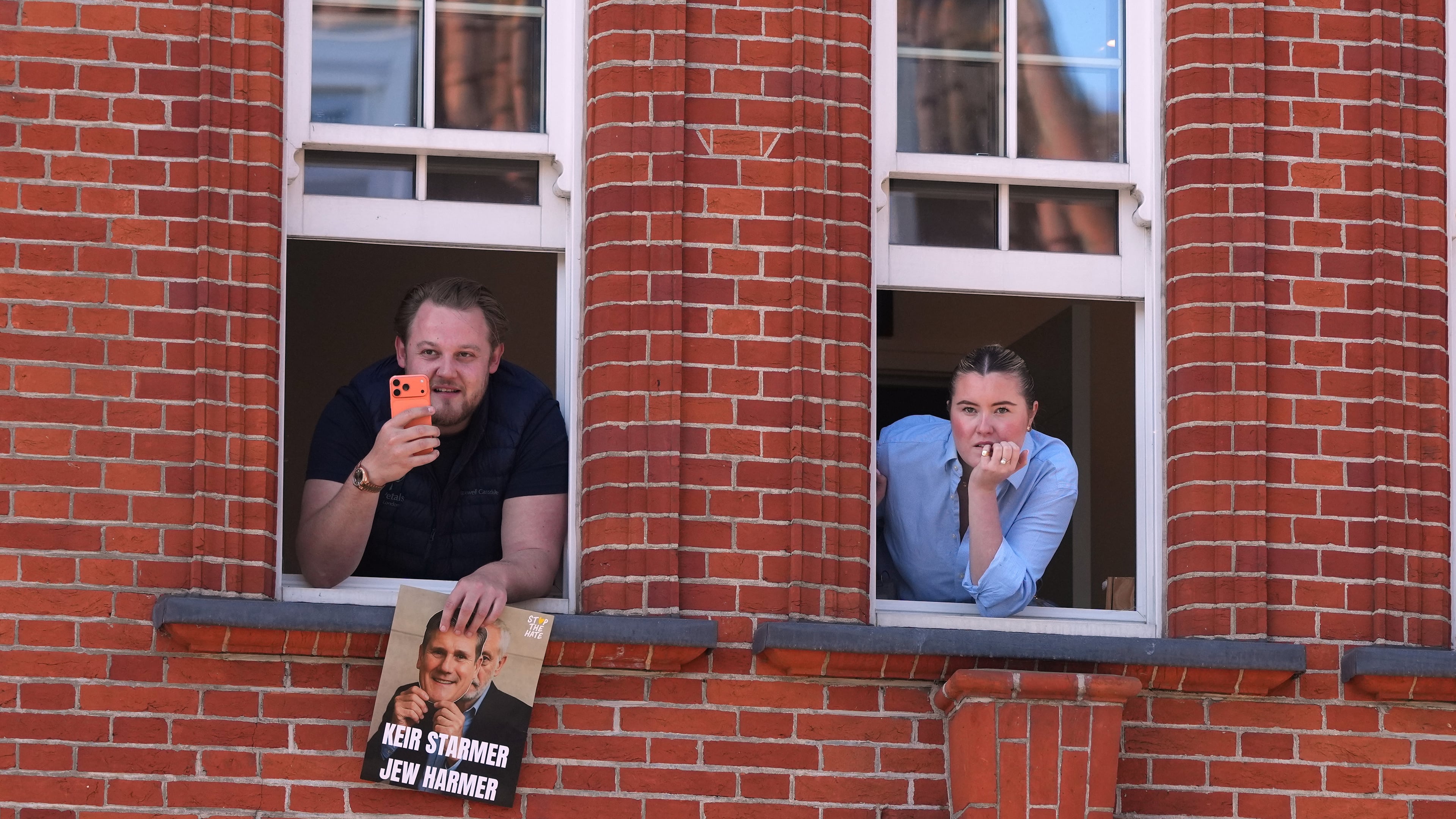 People look out of a window near the scene where two people were stabbed the previous day in the Golders Green neighbourhood, which has a large Jewish community, in London, Thursday, April 30, 2026. (AP Photo/Alastair Grant)