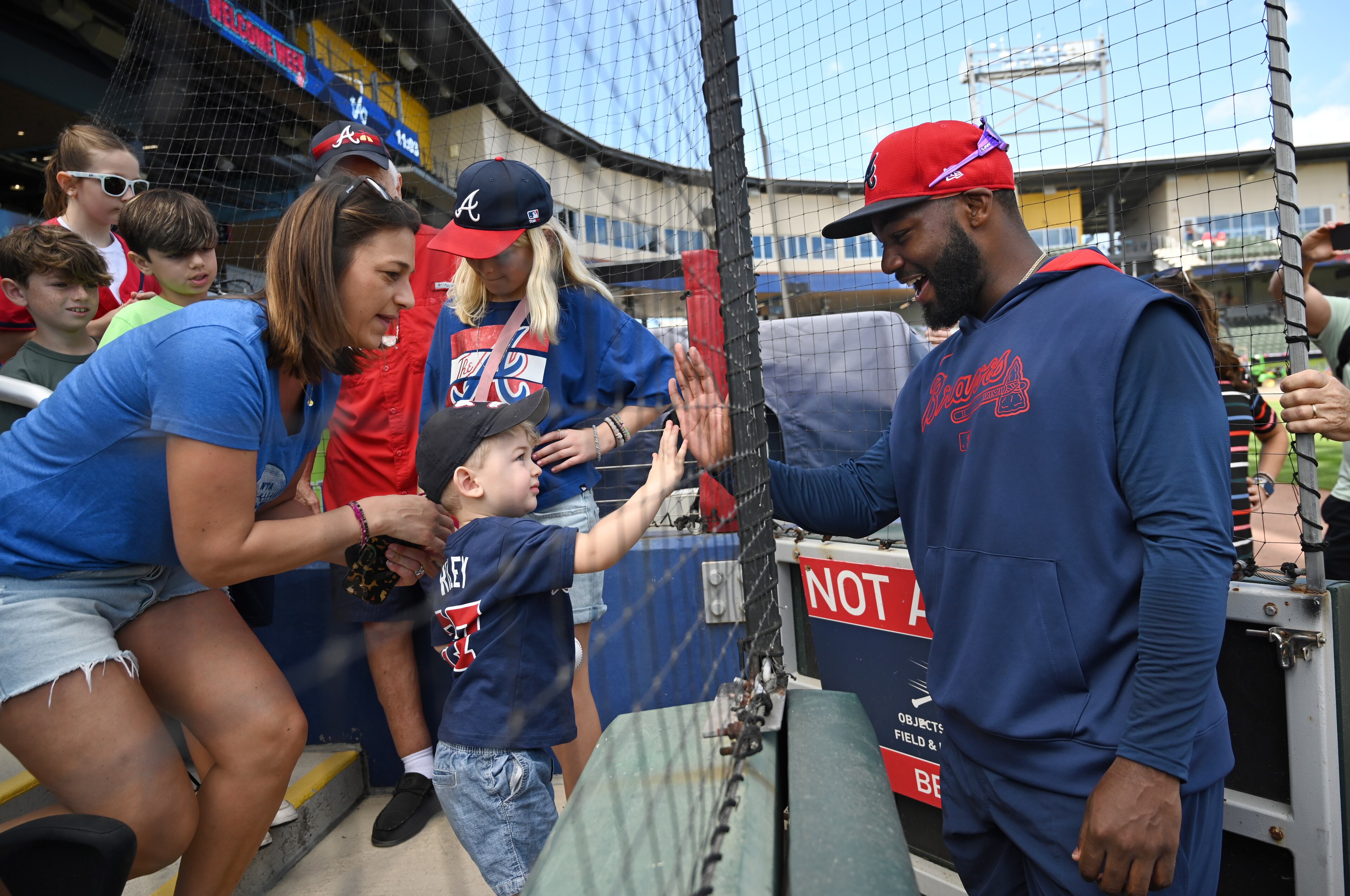 Atlanta Braves outfielder Michael Harris II (right) high-fives a young fan after taking batting practice during spring training workouts at CoolToday Park, Saturday, February 15, 2025, North Port, Florida. (Hyosub Shin / AJC)