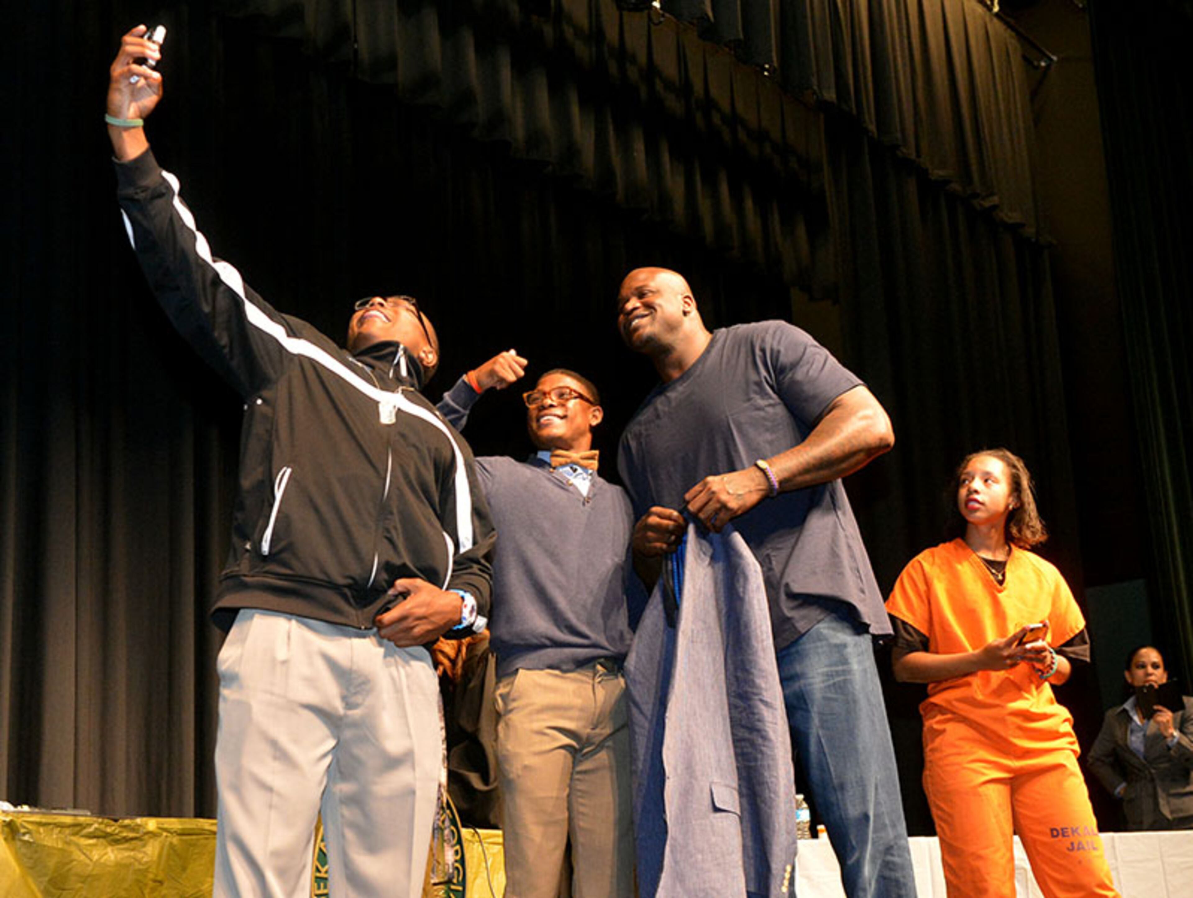 Arabia Mountain seniors Demetro Stevens (from left), Greg Phillips and Alexis Smoot take a selfie with former NBA star Shaquille O'Neal during the program.