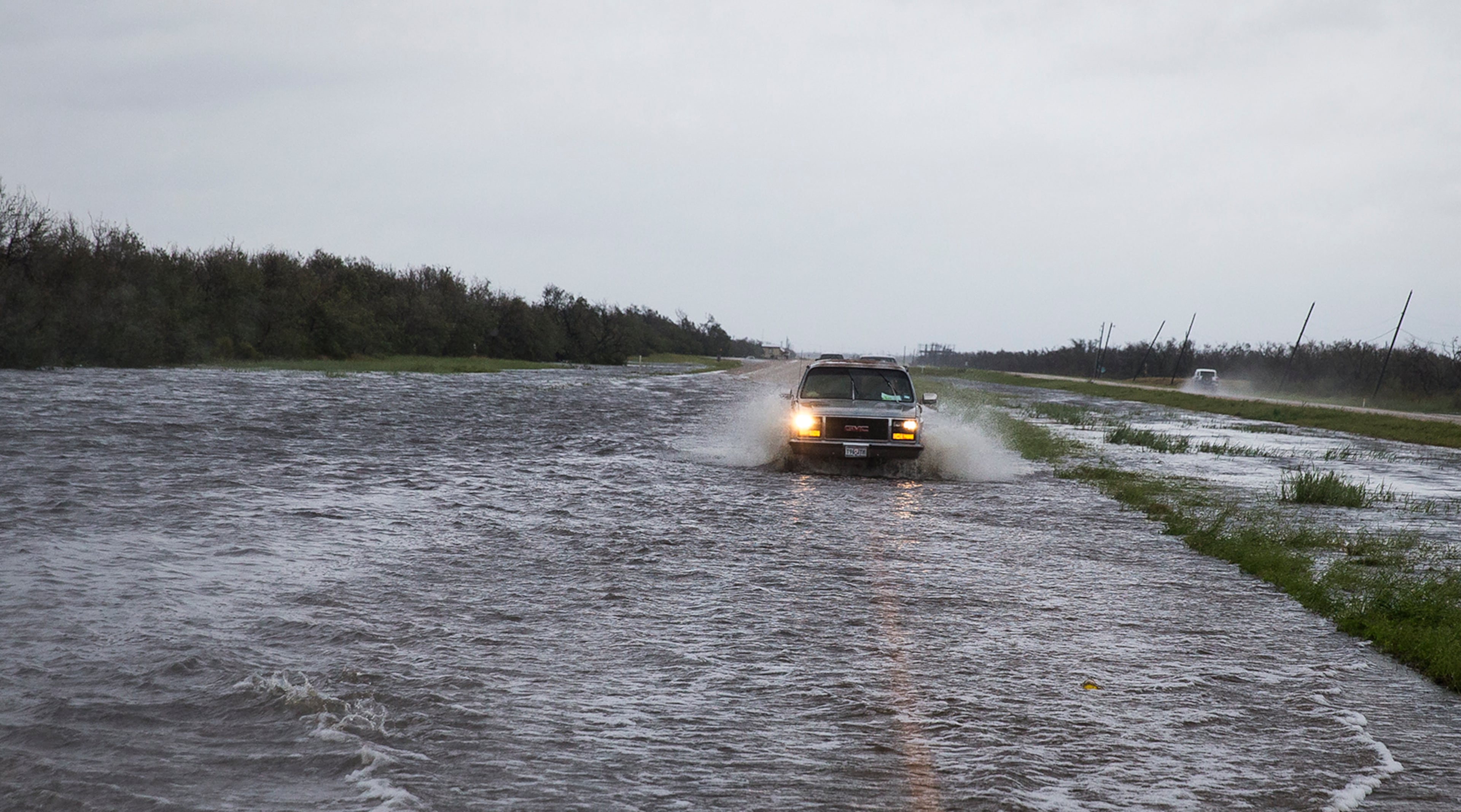 A vehicle passes through flood waters on TX-35 after Hurricane Harvey ripped through Rockport, Texas, on Saturday, August 26, 2017. The hurricane hit the Texas coast as a category 4 storm, damaging buildings and leaving tens of thousands without power. NICK WAGNER / AMERICAN-STATESMAN