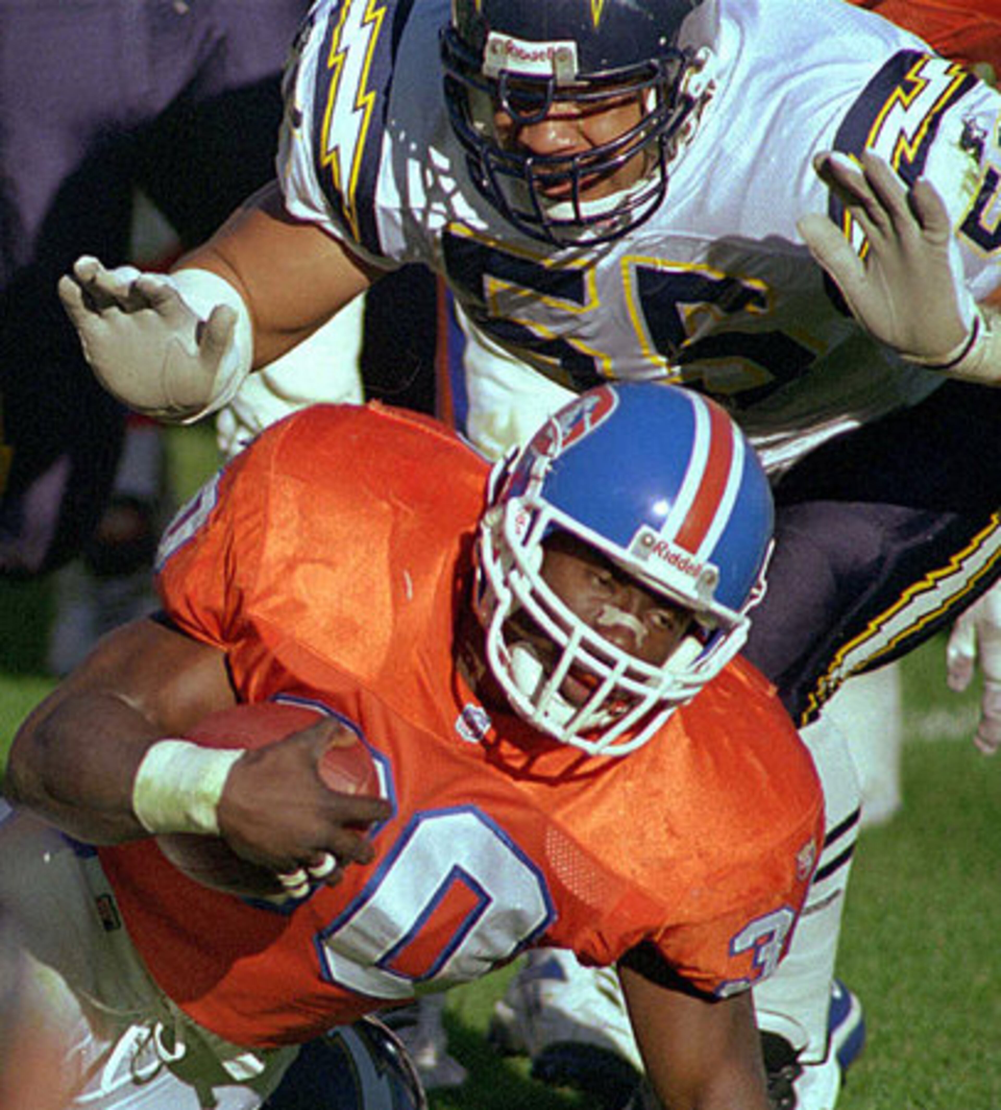 Junior Seau (top) wraps up Denver Broncos running back and former Bulldog, Terrell Davis, during a Nov. 19, 1995 game.