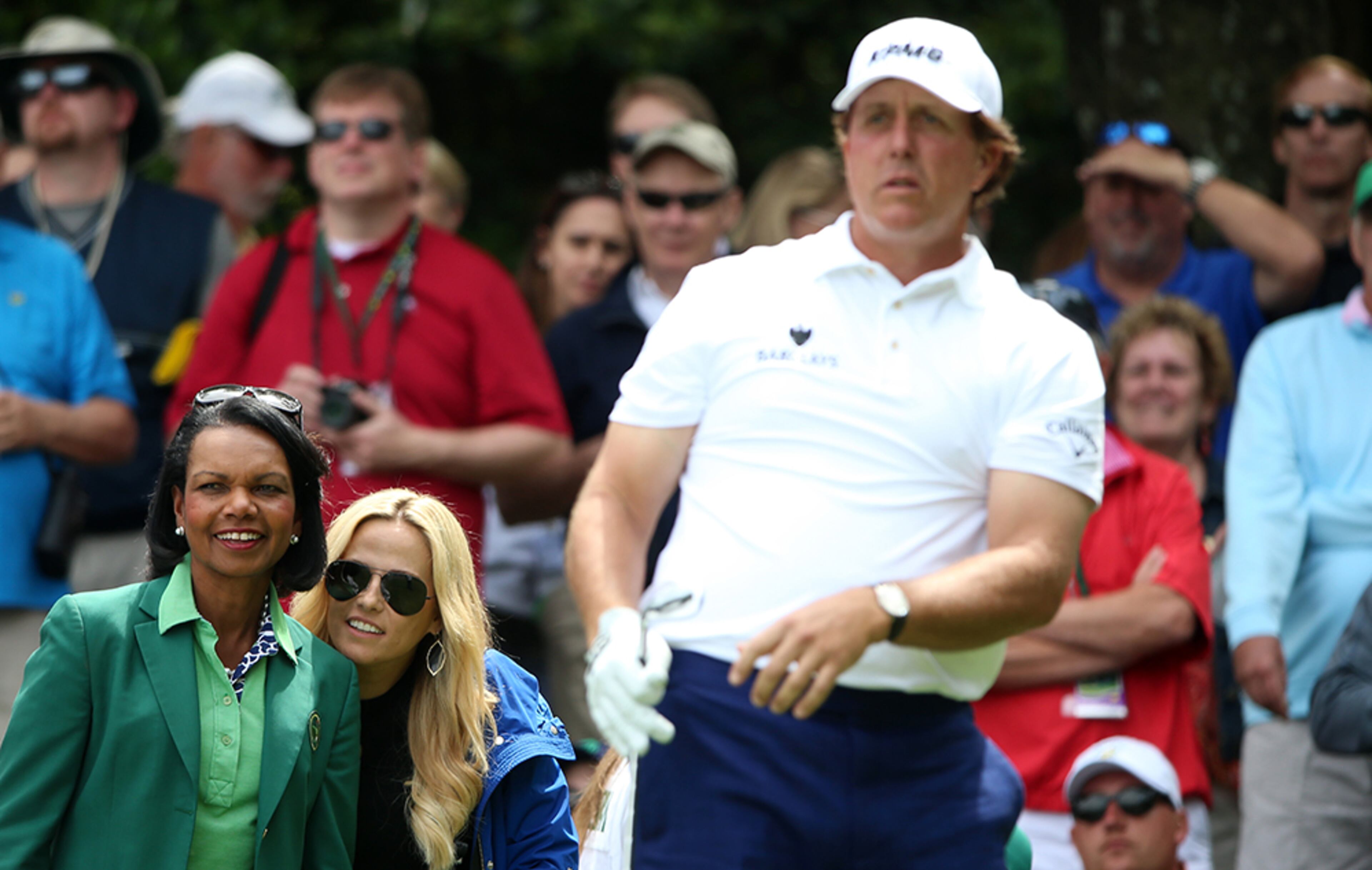 Phil Mickelson is watched by wife, Amy (second from left), and former U.S. Secretary of State Condoleezza Rice during the Par 3 Contest prior to the start of the 2016 Masters Tournament at Augusta National Golf Club on April 6, 2016 in Augusta.