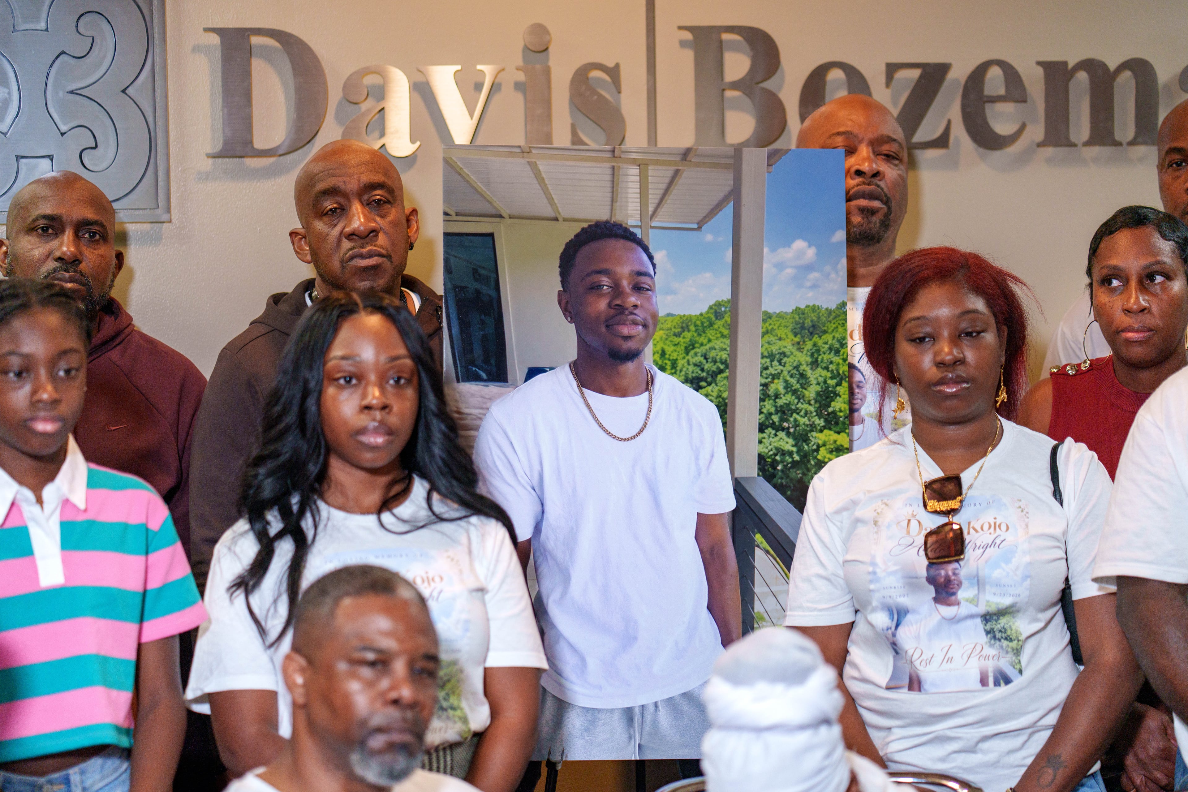 Family members gather around a portrait of David Addo-Wright during a news conference Friday, Oct. 2, 2026, about his death in the DeKalb County Jail. (Ben Hendren for the AJC)