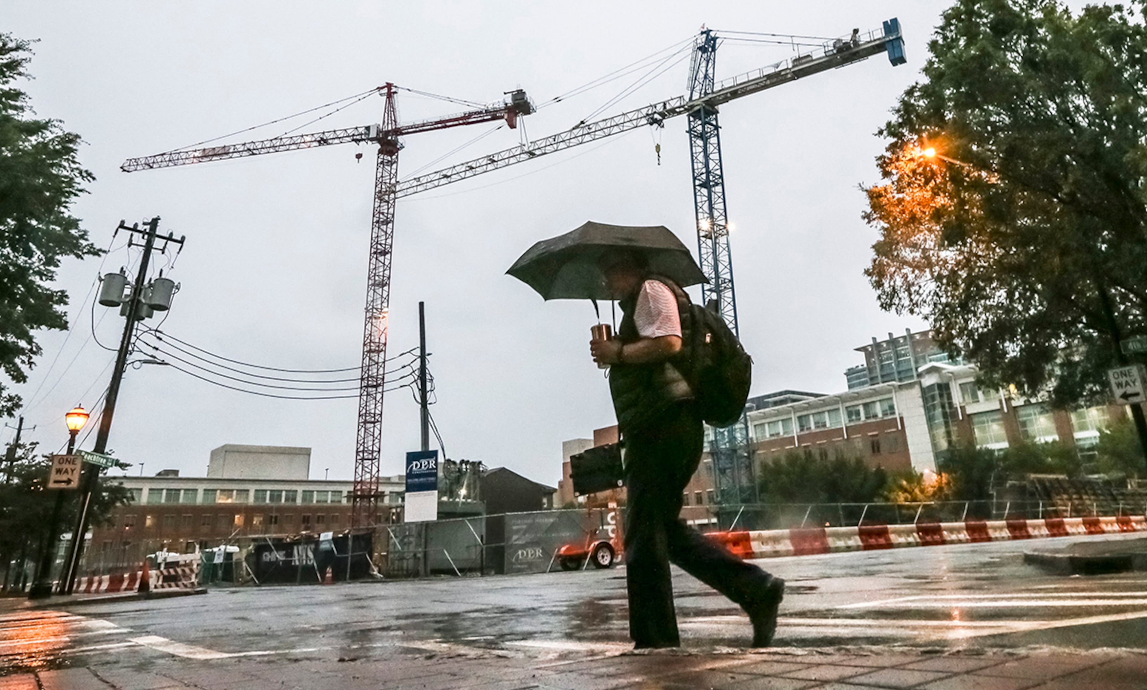 September 11, 2017 Atlanta: Rob Granberry passes the cranes on Fourth and West Peachtree streets in Midtown Atlanta on Monday, September 11, 2017 as tropical storm, Irma began to make its presence know in Atlanta on Monday, Sept. 11, 2017. The storm claimed at least one life in Georgia, state emergency management officials said Monday. The death occurred in Worth County. Further details werenât immediately available. Irmaâs staggering march up into northern Florida was expected to bring high winds and heavy rains to Atlanta Monday afternoon â though perhaps not quite as high or as heavy as earlier feared. Georgia Powerâs outage map showed 400,000 of its customers were down, and the electric membership cooperatives, as of 12:45 p.m., added another 268,000 to the total. Most of the failures were along the Georgia coast and in South Georgia. But the outages began to creep northward: 22,000 metro Atlanta customers had no power as of 12:20 p.m., the Georgia Power map showed. JOHN SPINK/JSPINK@AJC.COM