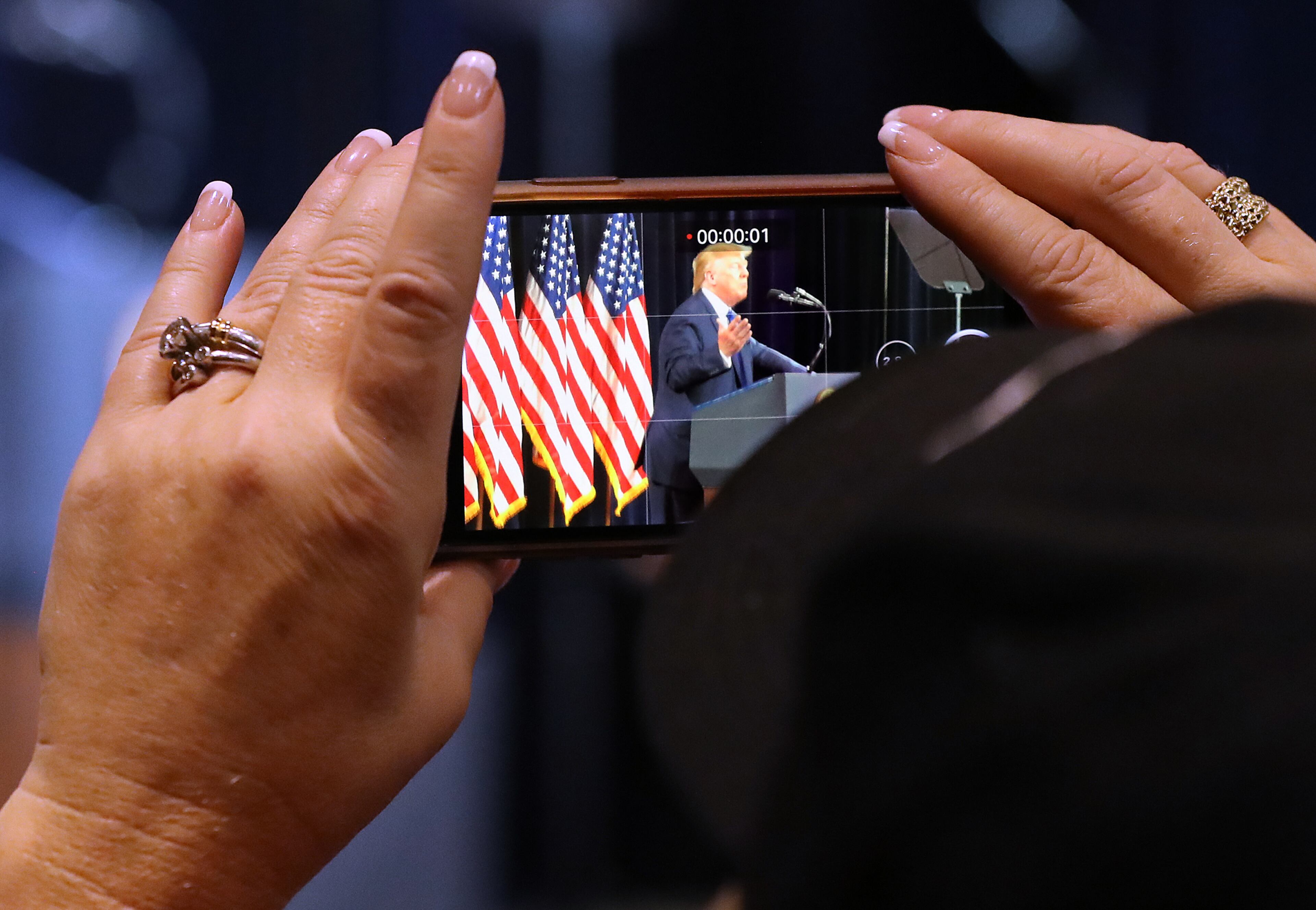November 8, 2019 Atlanta: A supporter rolls a video on her cell phone while President Donald Trump speaks at the Black Voices for Trump Coalition Rollout on Friday, November 8, 2019, in Atlanta. Curtis Compton/ccompton@ajc.com