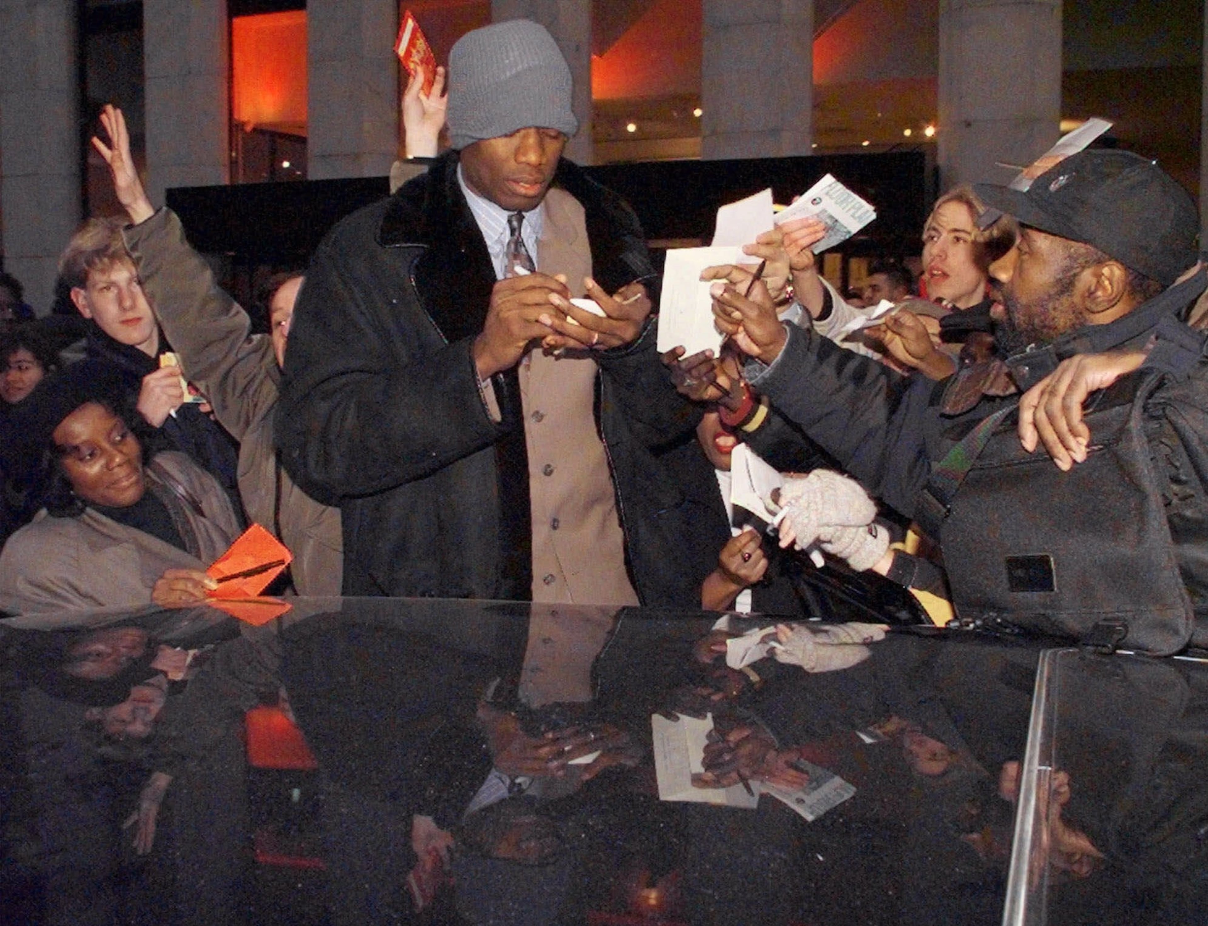 Dikembe Mutombo of the Atlanta Hawks signs autographs before getting into his limousine at the General Motors building in New York after voting on the NBA Players Association ratification Wednesday, Jan. 6, 1999. The NBA and the players' union reached an agreement today to end the 6-month-old lockout and save what's left of the season. (AP Photo/Mark Lennihan)