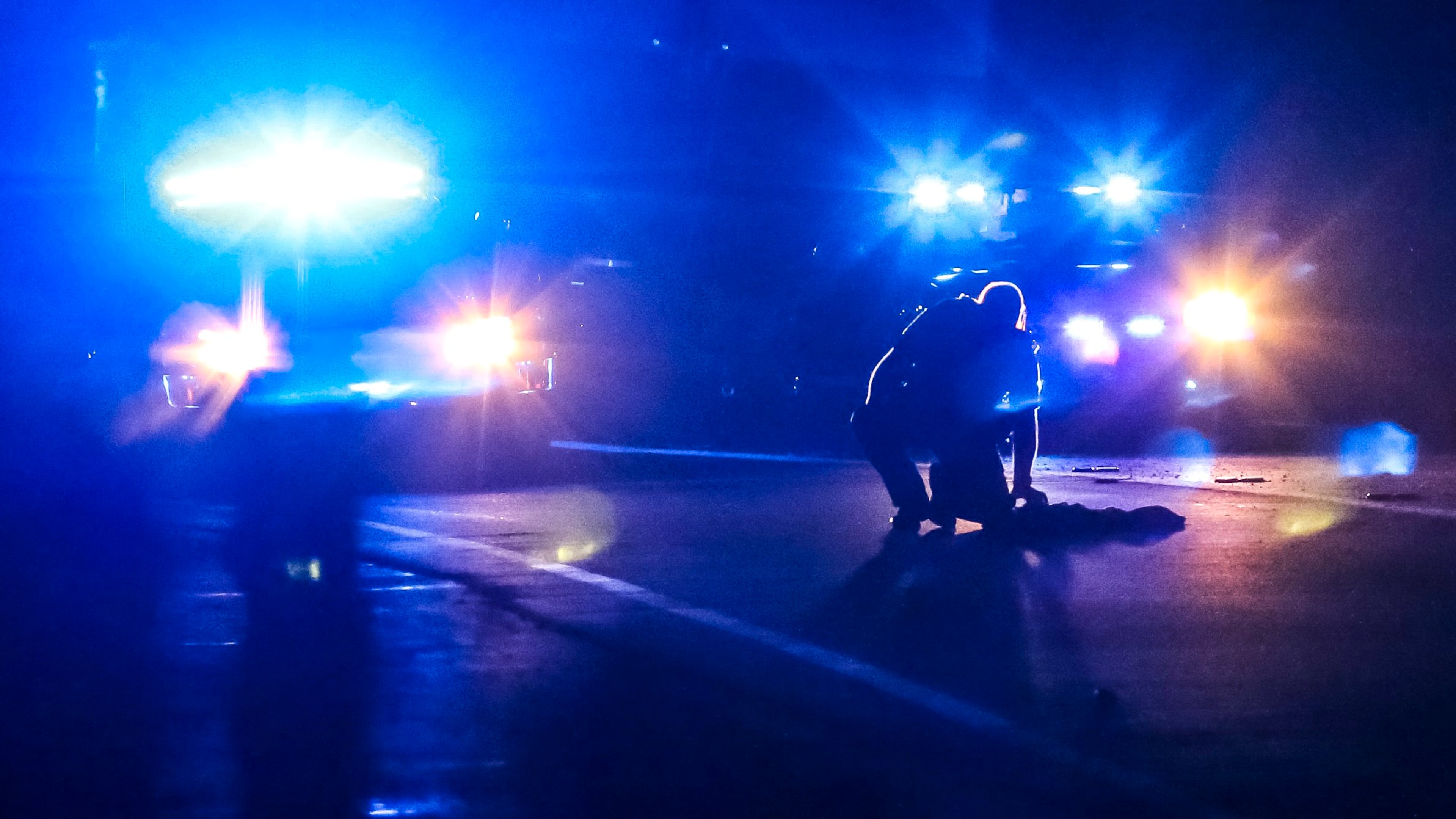 A DeKalb County police officer examines clothing left on the highway at the scene. A naked man sitting in the middle of I-85 North in DeKalb County was hit and killed in Sept. 2017. JOHN SPINK/JSPINK@AJC.COM