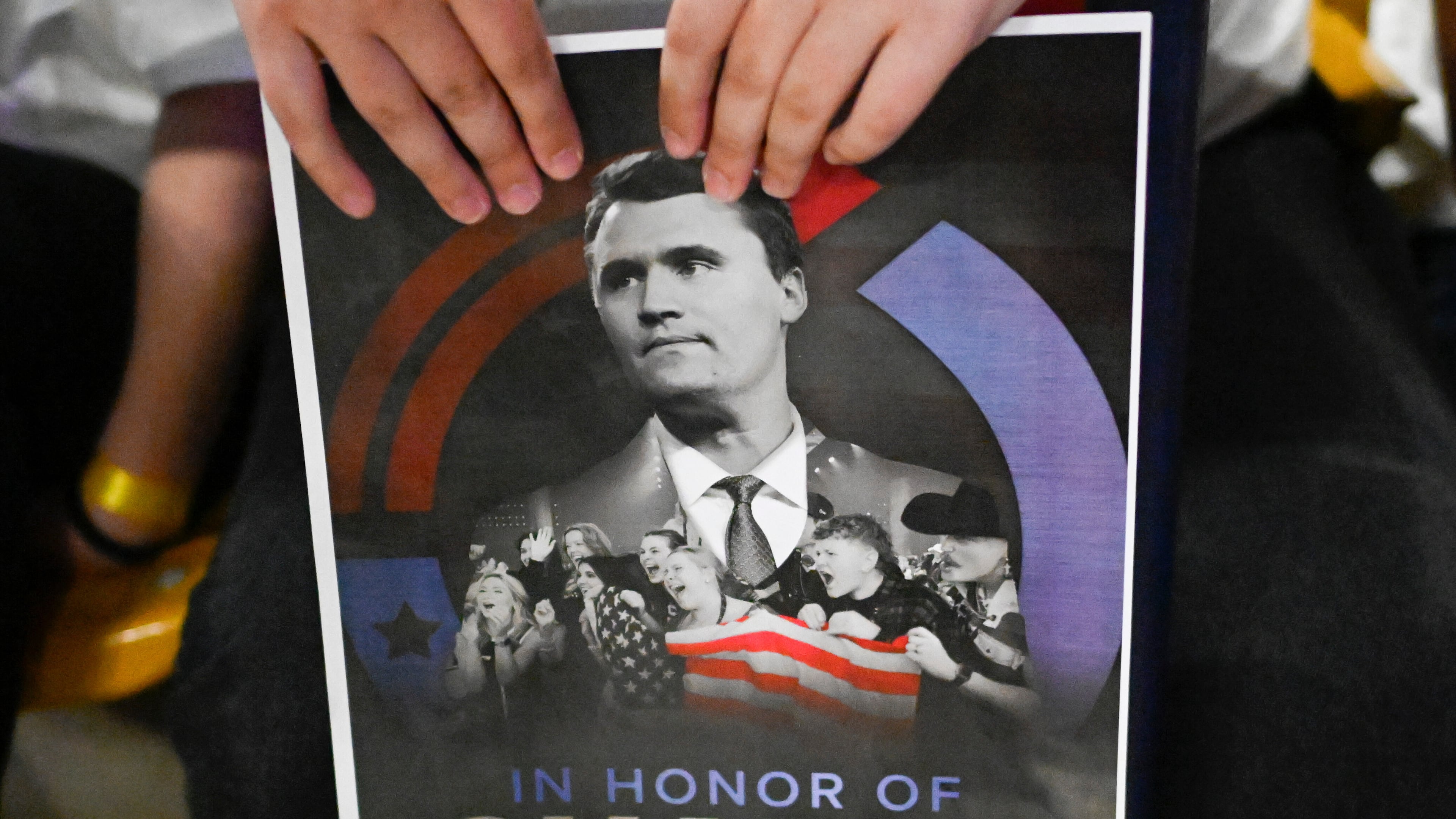 FILE - An attendee holds a poster of Charlie Kirk during a Turning Point USA rally, Sept. 30, 2025, in Logan, Utah. (AP Photo/Alex Goodlett, File)