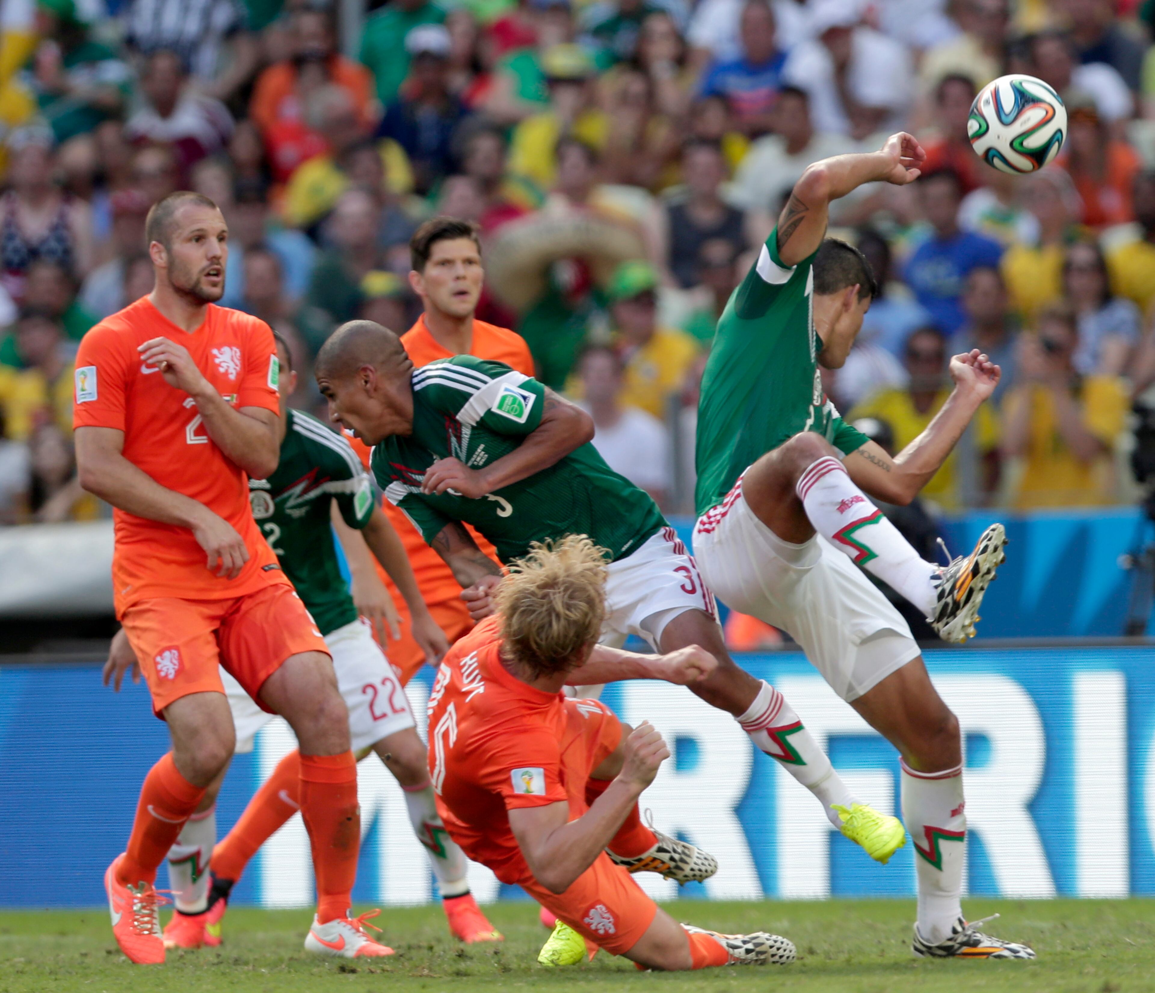 Netherlands' Dirk Kuyt, down, fights for the ball with Mexico's defenders during the World Cup round of 16 soccer match between the Netherlands and Mexico at the Arena Castelao in Fortaleza, Brazil, Sunday, June 29, 2014. (AP Photo/Marcio Jose Sanchez)