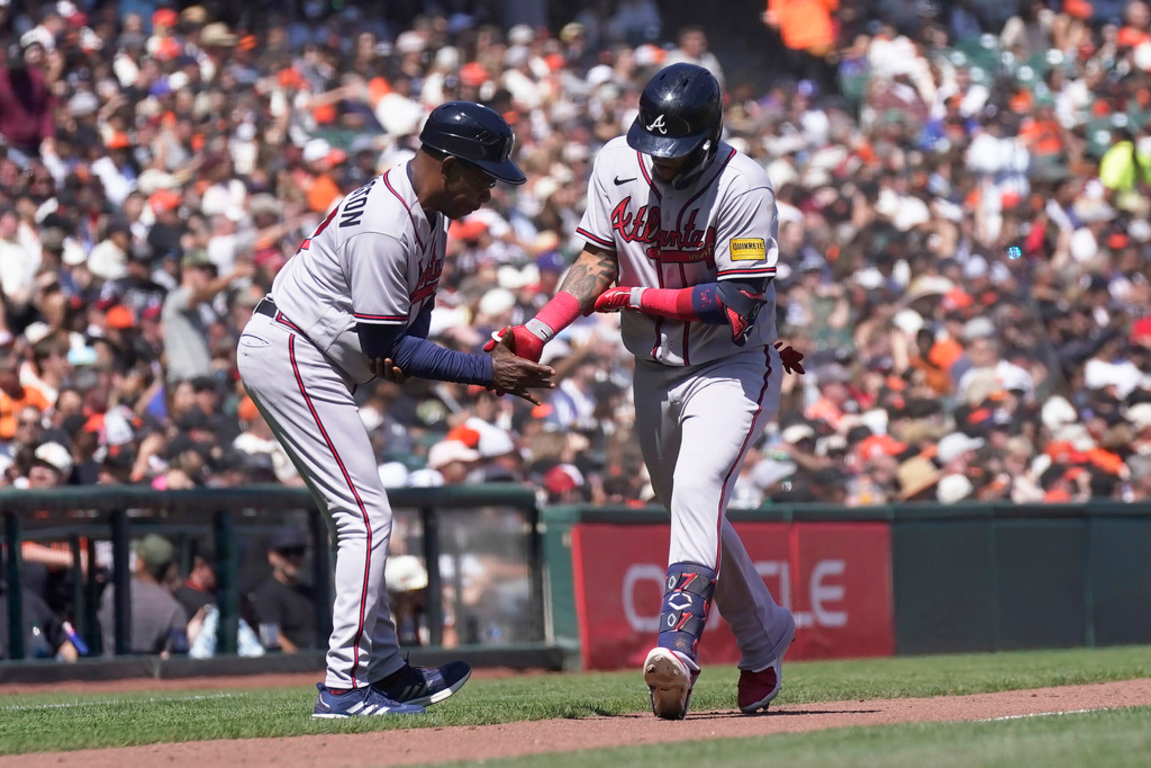 Atlanta Braves' Orlando Arcia, right, is congratulated by third base coach Ron Washington after hitting a home run against the San Francisco Giants during the sixth inning of a baseball game in San Francisco, Saturday, Aug. 26, 2023. (AP Photo/Jeff Chiu)