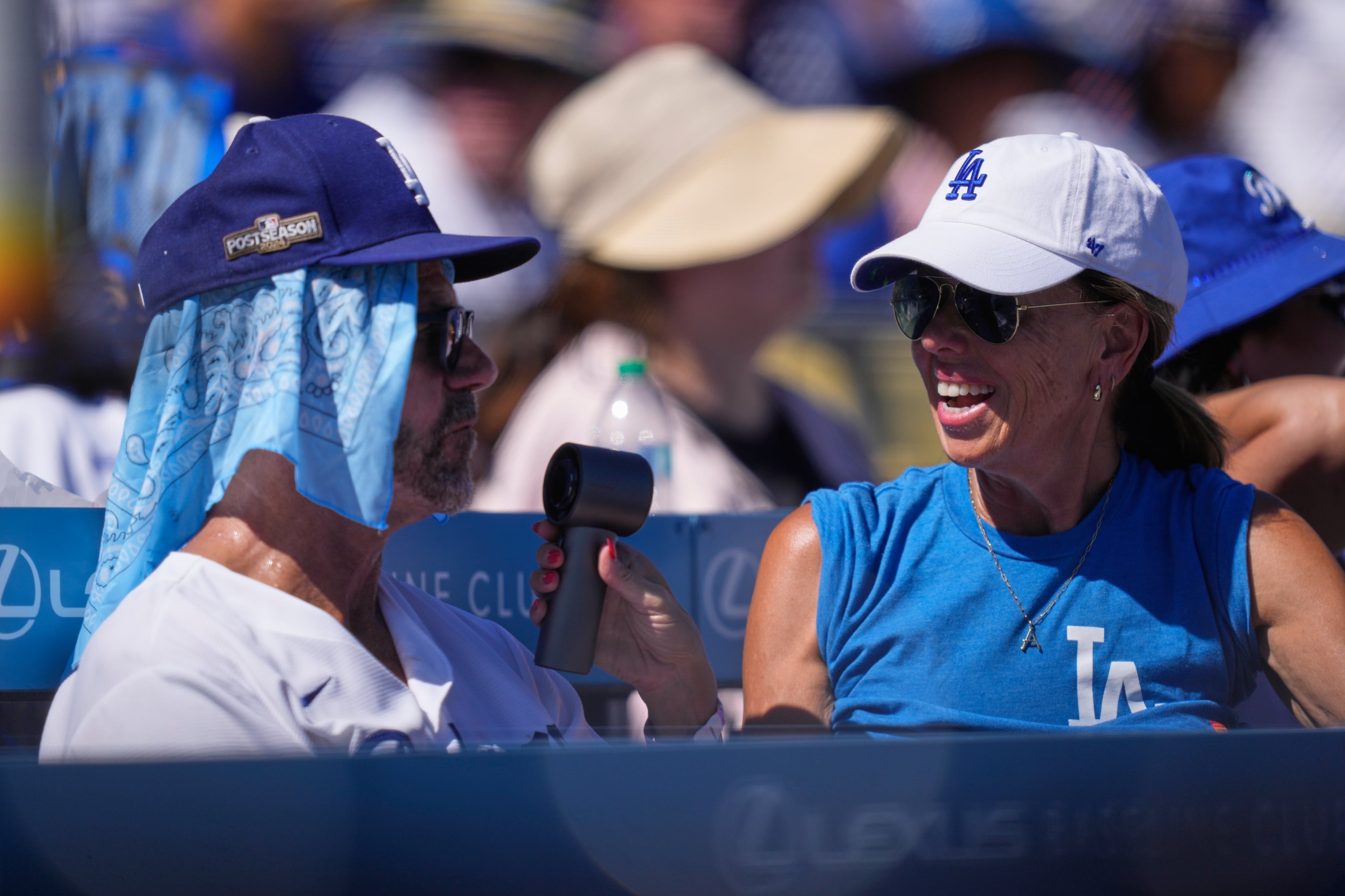 Fans try to deal with the heat during the first inning of Game 1 of a National League Division Series baseball game between the Los Angeles Dodgers and the Atlanta Braves Saturday, Oct. 3, 2026, in Los Angeles. (Mark J. Terrill/AP)