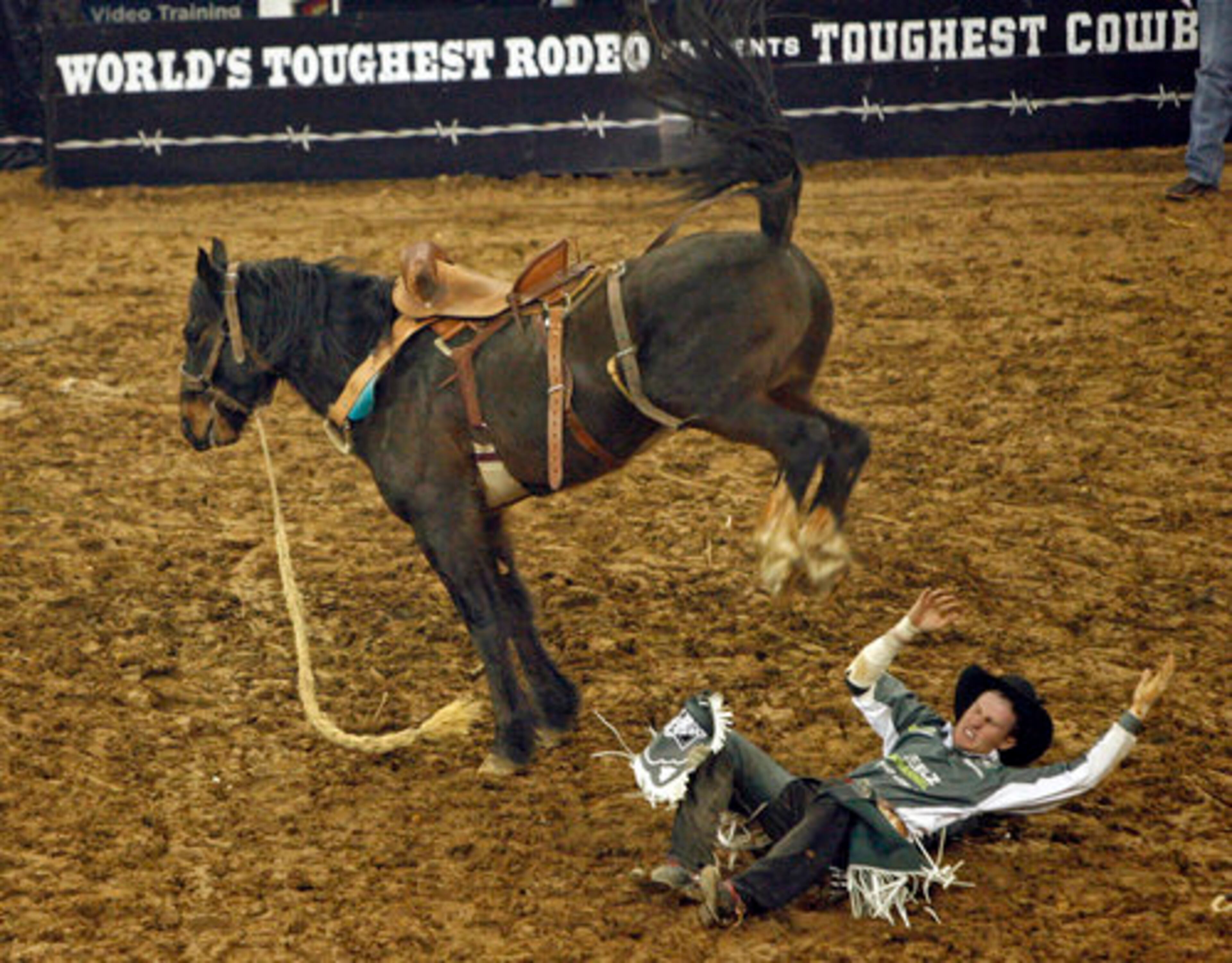 Cowboy Mark Fisher, of Weatherford, Texas, gets tossed to the dirt after he competed in the Saddle Bronc Riding portion.