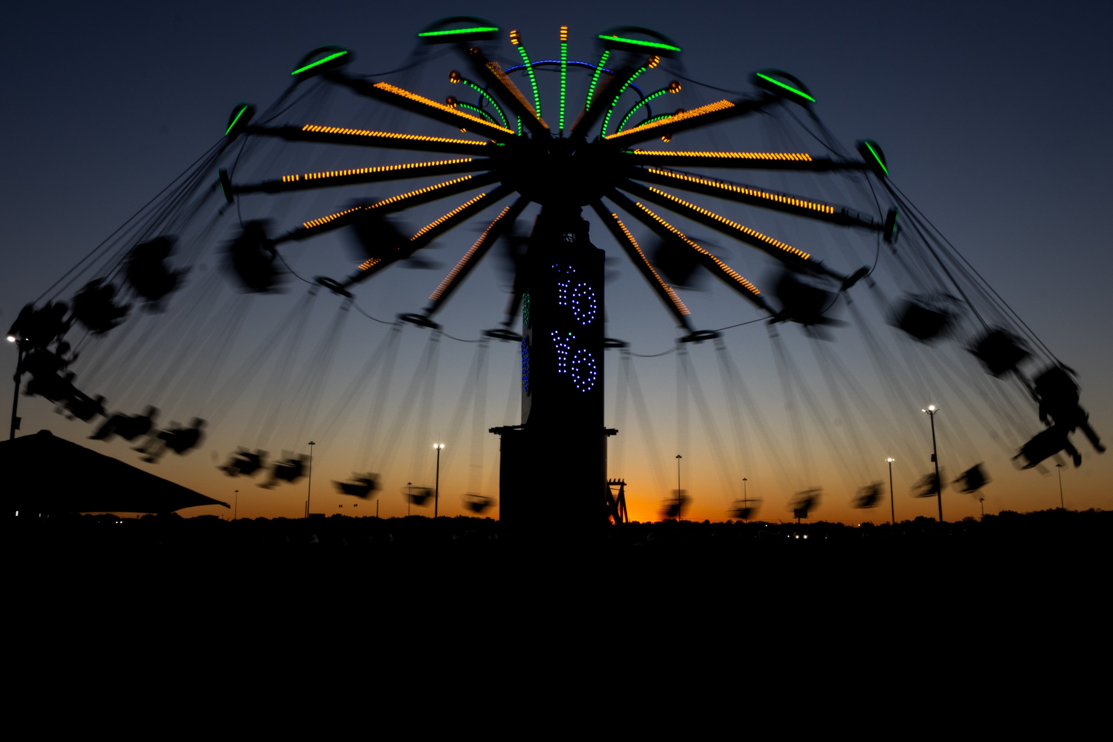 The sun sinks below the horizon as riders of the Yo-Yo swing around at the 37th annual Georgia National Fair on Saturday, Oct. 17, 2026. (Wesley Webb/UGA Photojournalism Workshop)