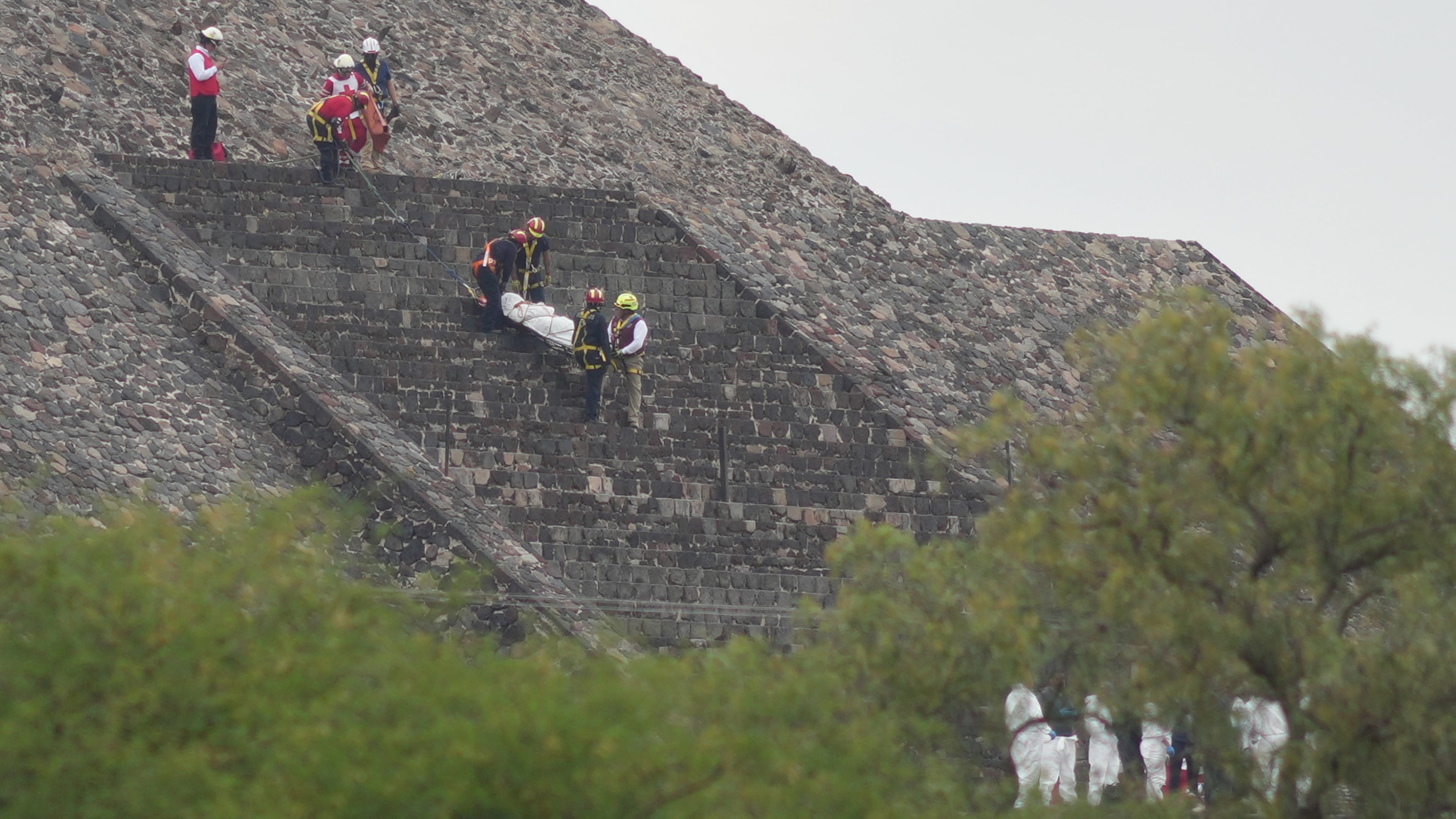 Forensic workers carry the body of a victim down a pyramid after authorities said a gunman opened fire, in Teotihuacan, Mexico, Monday, April 20, 2026. (AP Photo/Eduardo Verdugo)