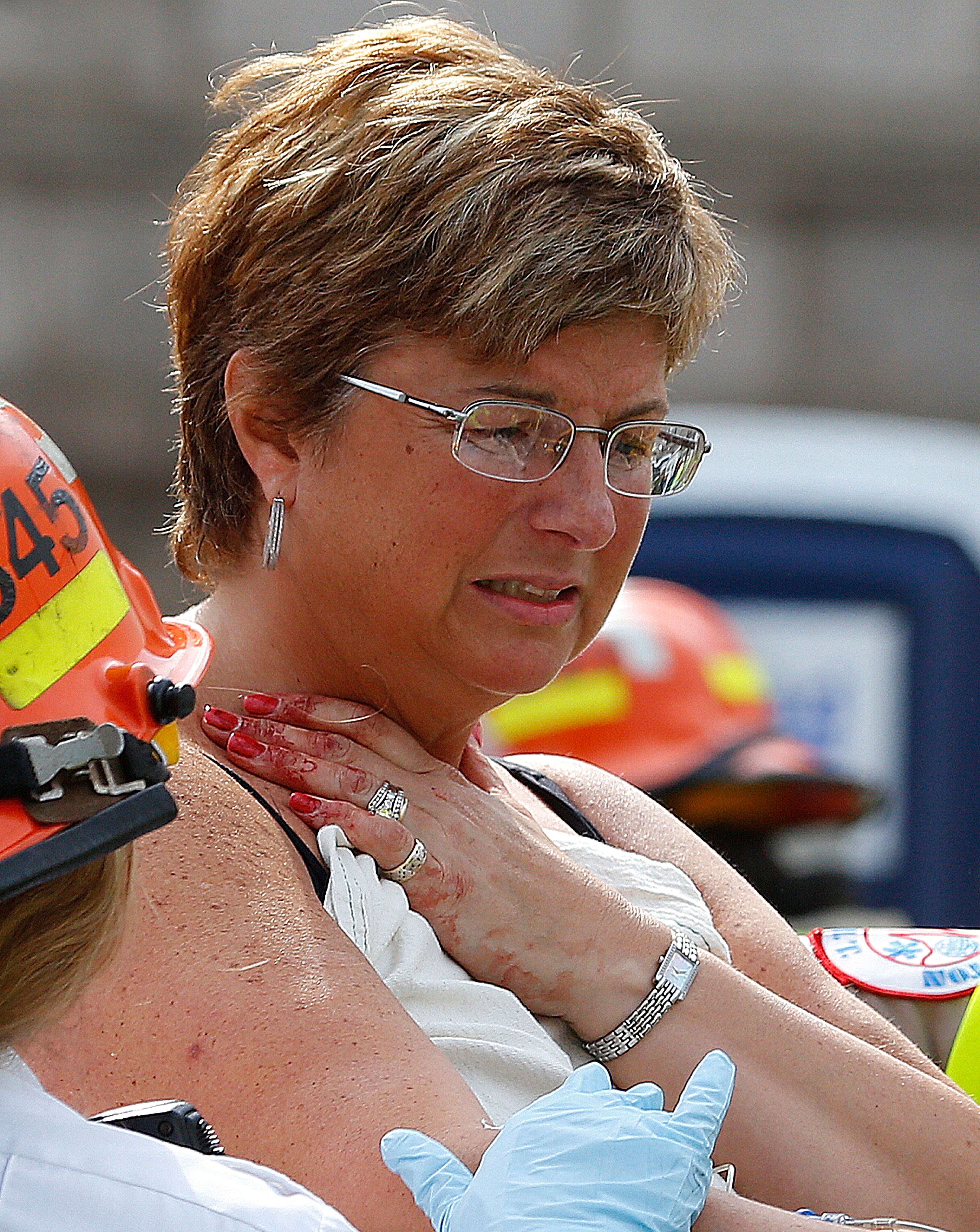 BOSTON, MA - APRIL 15: A woman, with blood on fingers, is loaded into an ambulance after being injured after two bombs exploded on the marathon route on April 15, 2013 in Boston, Massachusetts. Two people are confirmed dead and at least 23 injured after two explosions went off near the finish line to the marathon. (Photo by Jim Rogash/Getty Images)