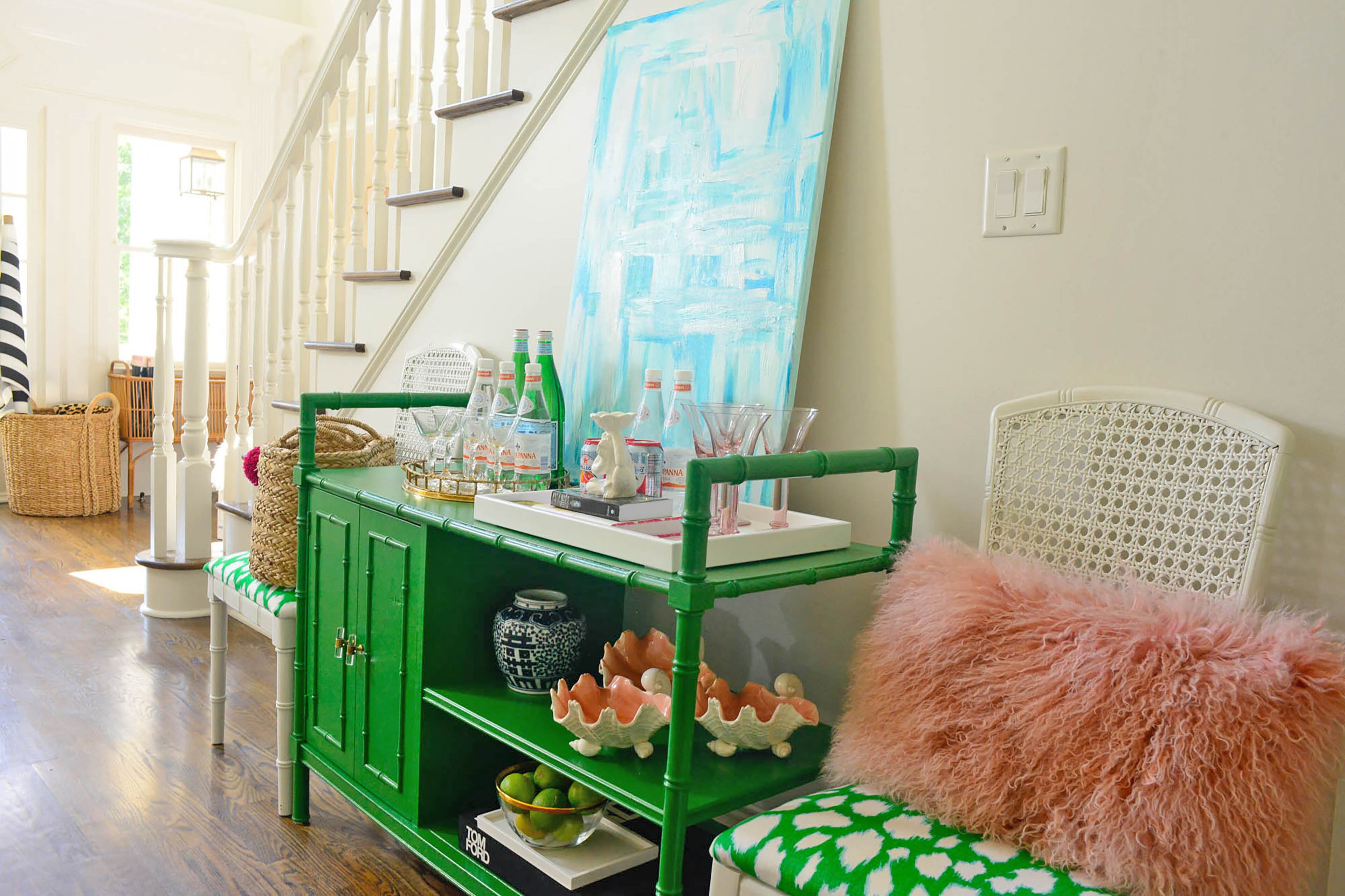 The bamboo bar cart, a spruced up Craigslist find, sits in the foyer. "I wanted this house to be like a blank slate where I could take my interior design paintbrush and brush strokes of color and surprise," said Edee, who painted most of the interior walls Sherwin-Williams Pearly White.