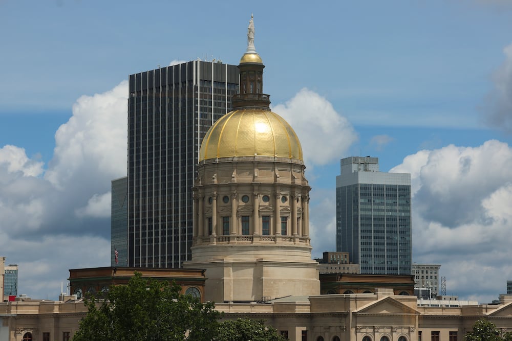 The Georgia state Capitol dome is shown through the windows of the Nathan Deal Judicial Center in June. (Jason Getz/AJC)