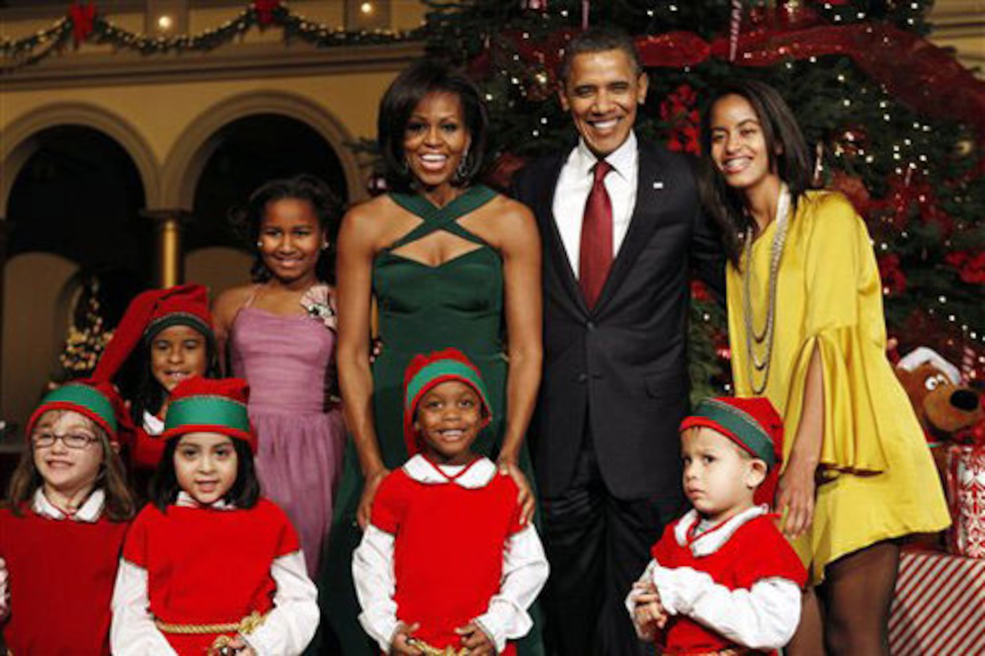 Caption: The first family, Sasha Obama, back left, first lady Michelle Obama, President Barack Obama, and Malia Obama, pose with children dressed like elves at the annual Christmas in Washington taping at the National Building Museum in Washington, Sunday, Dec. 11, 2011. Host Conan O'Brien, Justin Bieber, Cee Lo Green, Jennifer Hudson, Victoria Justice and The Band Perry were to perform.