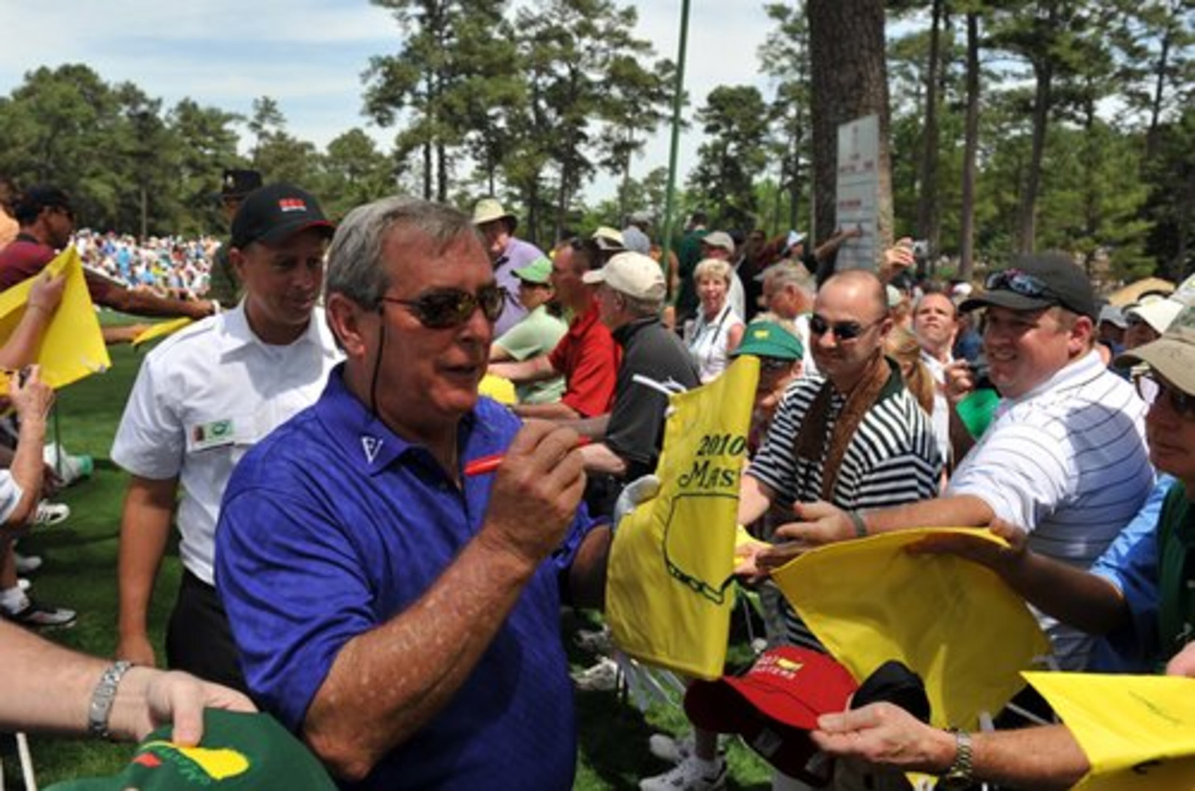 Former Masters champion Fuzzy Zoeller always has a pen in hand for autographs. Joking with fans while signing autographs while playing the par three contest Zoeller said "I'm starting to figure out why it takes me 5 hours to play a round of golf". Par three contest at the Augusta National Wednesday April 7, 2010.