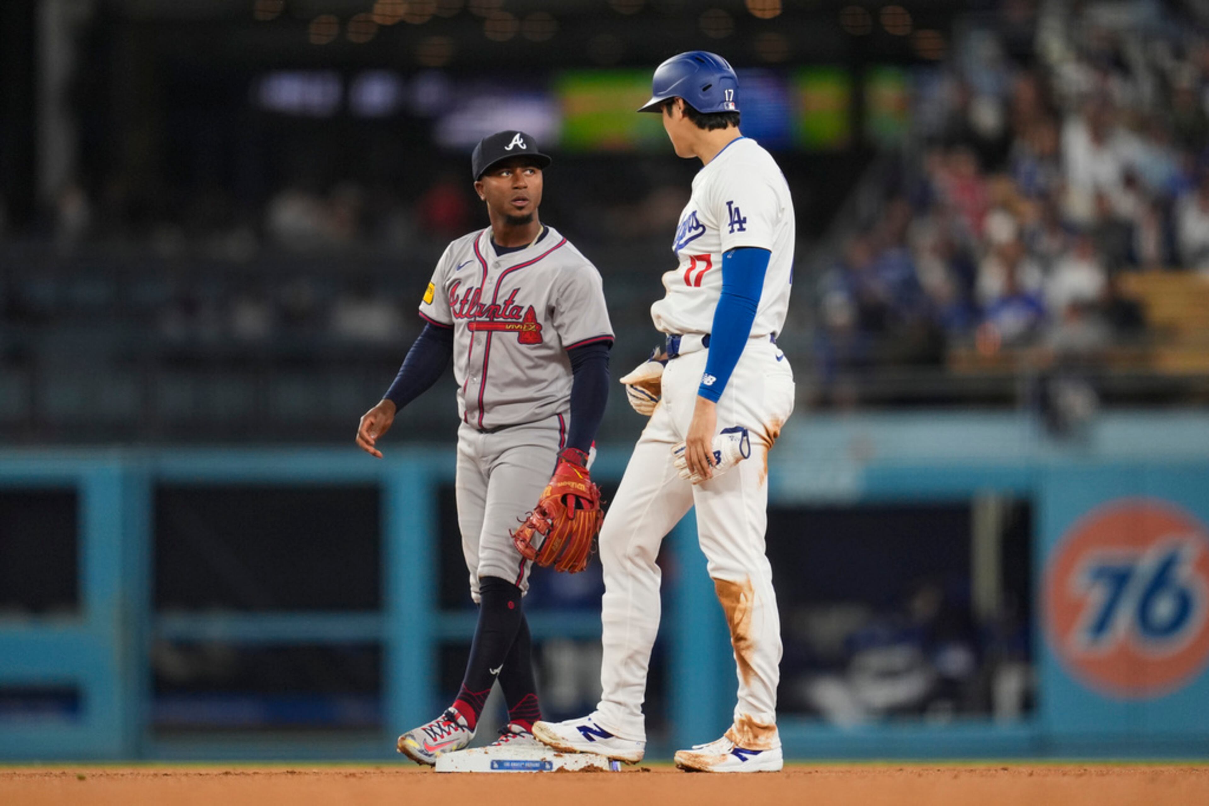 Los Angeles Dodgers designated hitter Shohei Ohtani (17) talks with Atlanta Braves second baseman Ozzie Albies during the third inning of a baseball game in Los Angeles, Friday, May 3, 2024. (AP Photo/Ashley Landis)