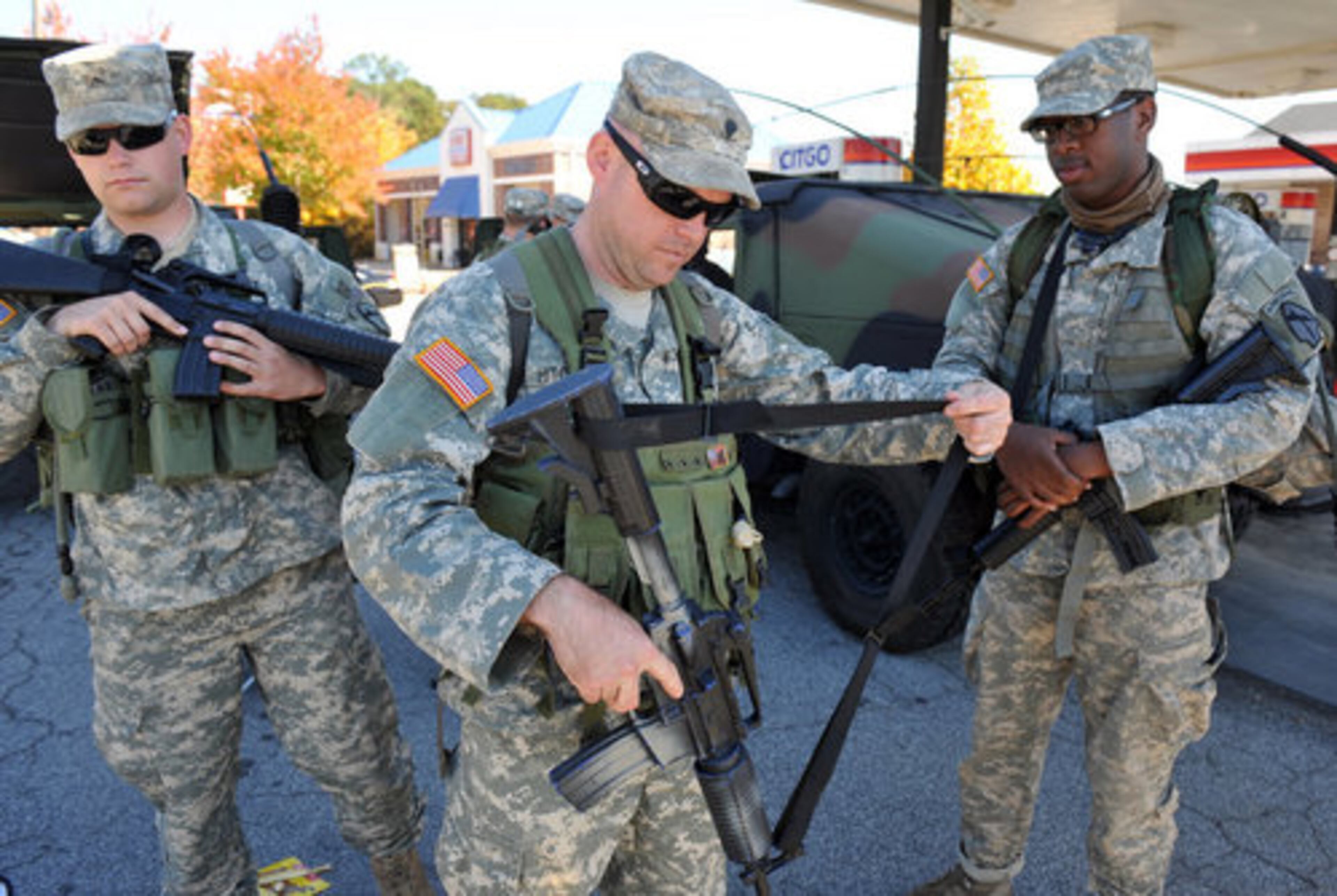 Spc. Cory Hitchock , center, readies his gear after a brief rest stop along the 100-plus mile march. A group of 10 soldiers from the Georgia Army National Guard long range surveillance unit is on a quest to commemorate the 100 plus mile march made by Easy Company of the 101st Airborne Division in preparation of WWII.