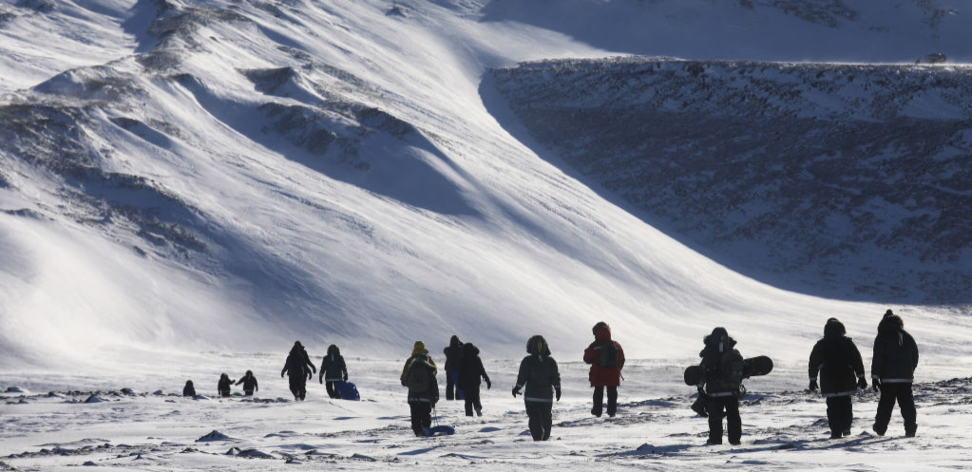 PITUFFIK, GREENLAND - MARCH 25: People hike near Thule Air Base on March 25, 2017 in Pituffik, Greenland. NASA's Operation IceBridge is flying research missions out of Thule Air Base and other Arctic locations during their annual Arctic spring campaign. Thule Air Base is the U.S. military's northernmost base located some 750 miles above the Arctic Circle. NASA's Operation IceBridge has been studying how polar ice has evolved over the past nine years and is currently flying a set of eight-hour research flights over ice sheets and the Arctic Ocean to monitor Arctic ice loss aboard a retrofitted 1966 Lockheed P-3 aircraft. According to NASA scientists and the National Snow and Ice Data Center (NSIDC), sea ice in the Arctic appears to have reached its lowest maximum wintertime extent ever recorded on March 7. Scientists have said the Arctic has been one of the regions hardest hit by climate change. (Photo by Mario Tama/Getty Images)