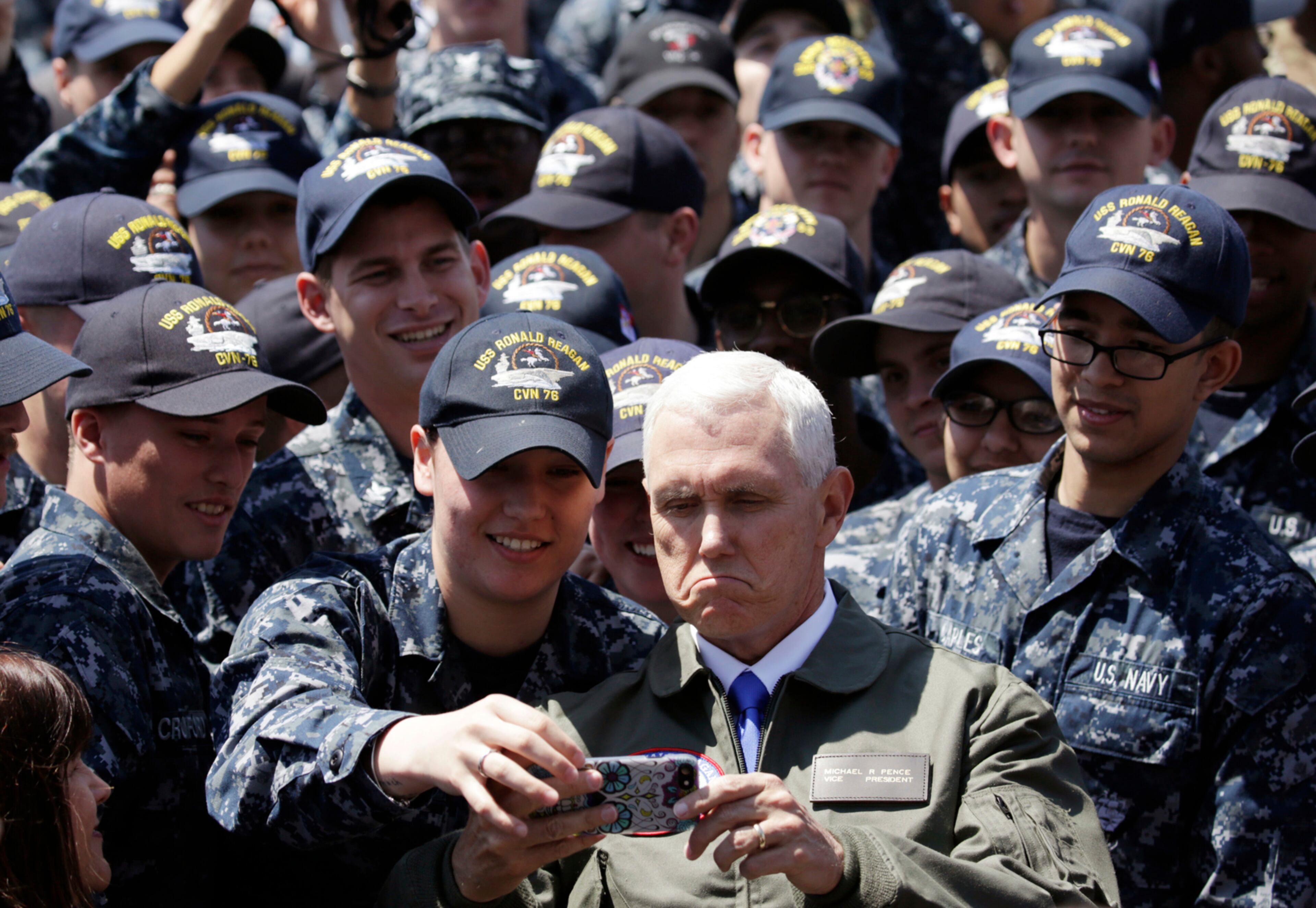 U.S. Vice President Mike Pence, center right at bottom, takes a selfie with U.S. servicemen on the flight deck of U.S. navy nuclear-powered aircraft carrier USS Ronald Reagan, at the U.S. Navy's Yokosuka base in Yokosuka, south of Tokyo, Wednesday, April 19, 2017. (AP Photo/Eugene Hoshiko)