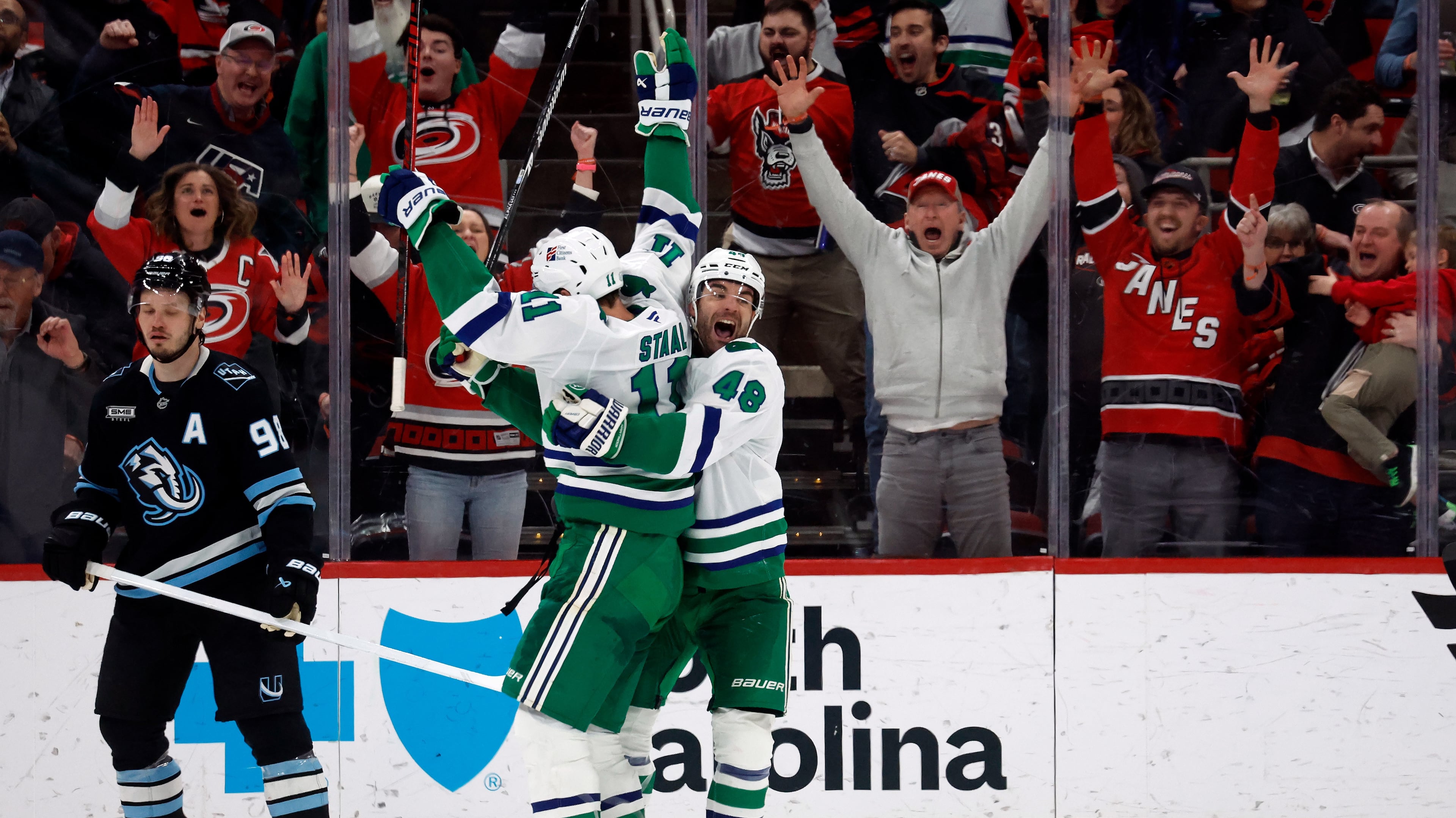 Carolina Hurricanes' Jordan Staal (11) is celebrates after his winning goal with teammate Jordan Martinook (48) with Utah Mammoth's Mikhail Sergachev (98) nearby during the third period of an NHL hockey game in Raleigh, N.C., Thursday, Jan. 29, 2026. (AP Photo/Karl DeBlaker)
