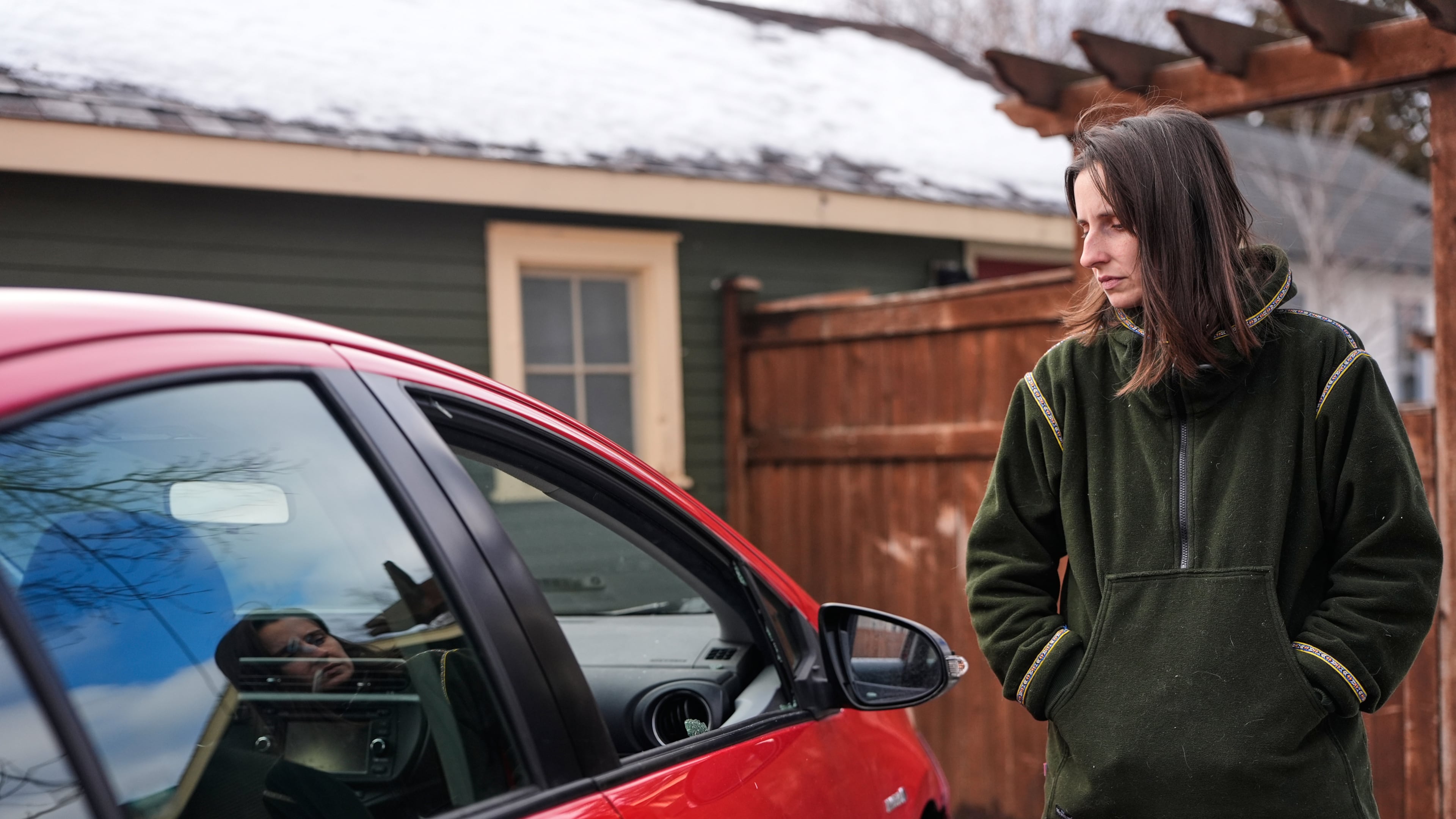 Patty O'Keefe, a U.S. citizens who was arrested while following federal agents' vehicles and briefly held at a federal facility in Minneapolis, stands next to her car showing that her front driver's side window was smashed in, Tuesday, Jan. 13, 2026. (AP Photo/Jen Golbeck)