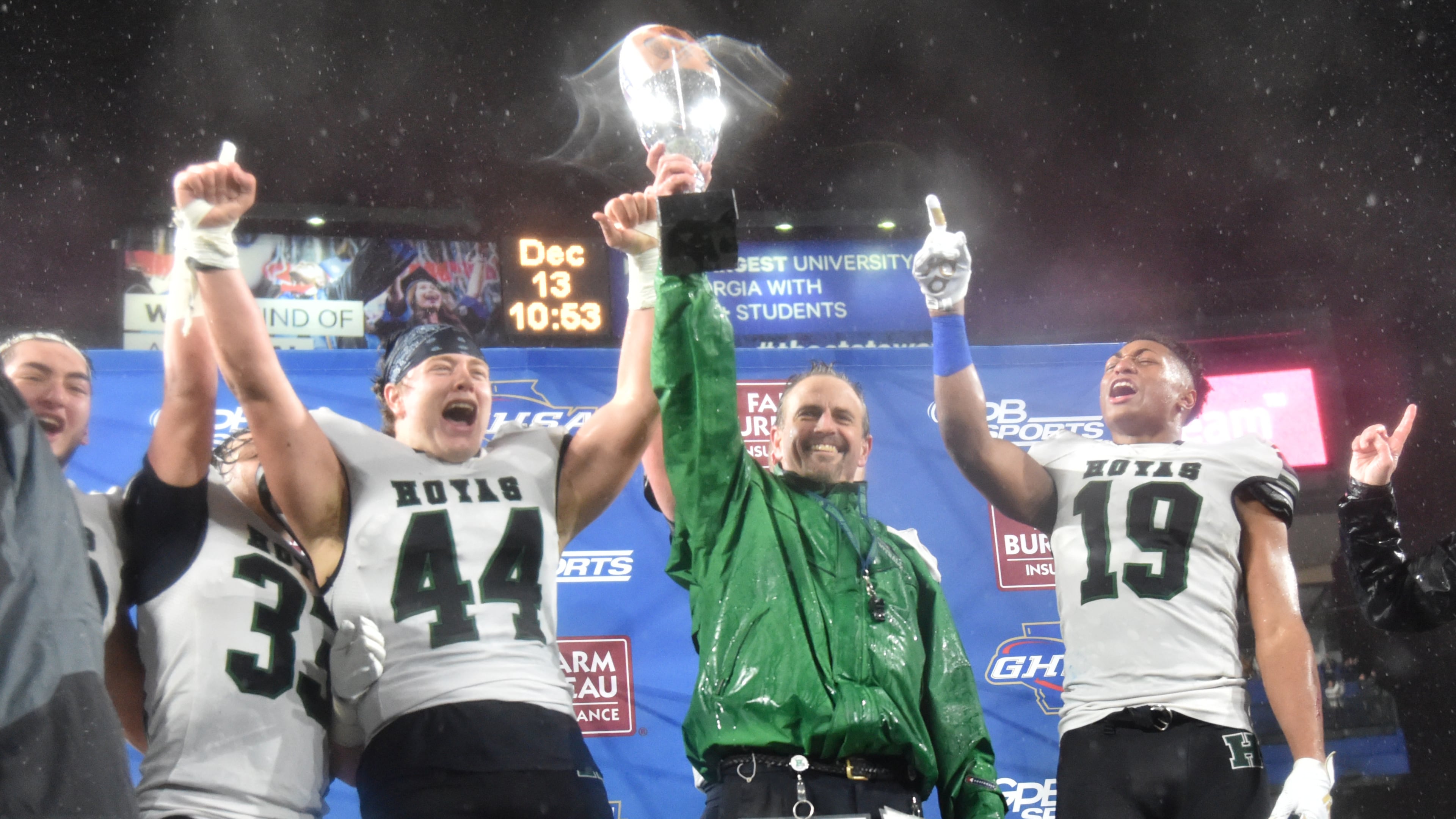 Harrison head coach Matt Dickmann and player Mason Bollin (44) hold their championship trophy after the AAAAAA state championship game at Georgia State Stadium on Friday, December 13, 2019. Harrison won 20-7 over Allatoona. (Hyosub Shin / Hyosub.Shin@ajc.com)