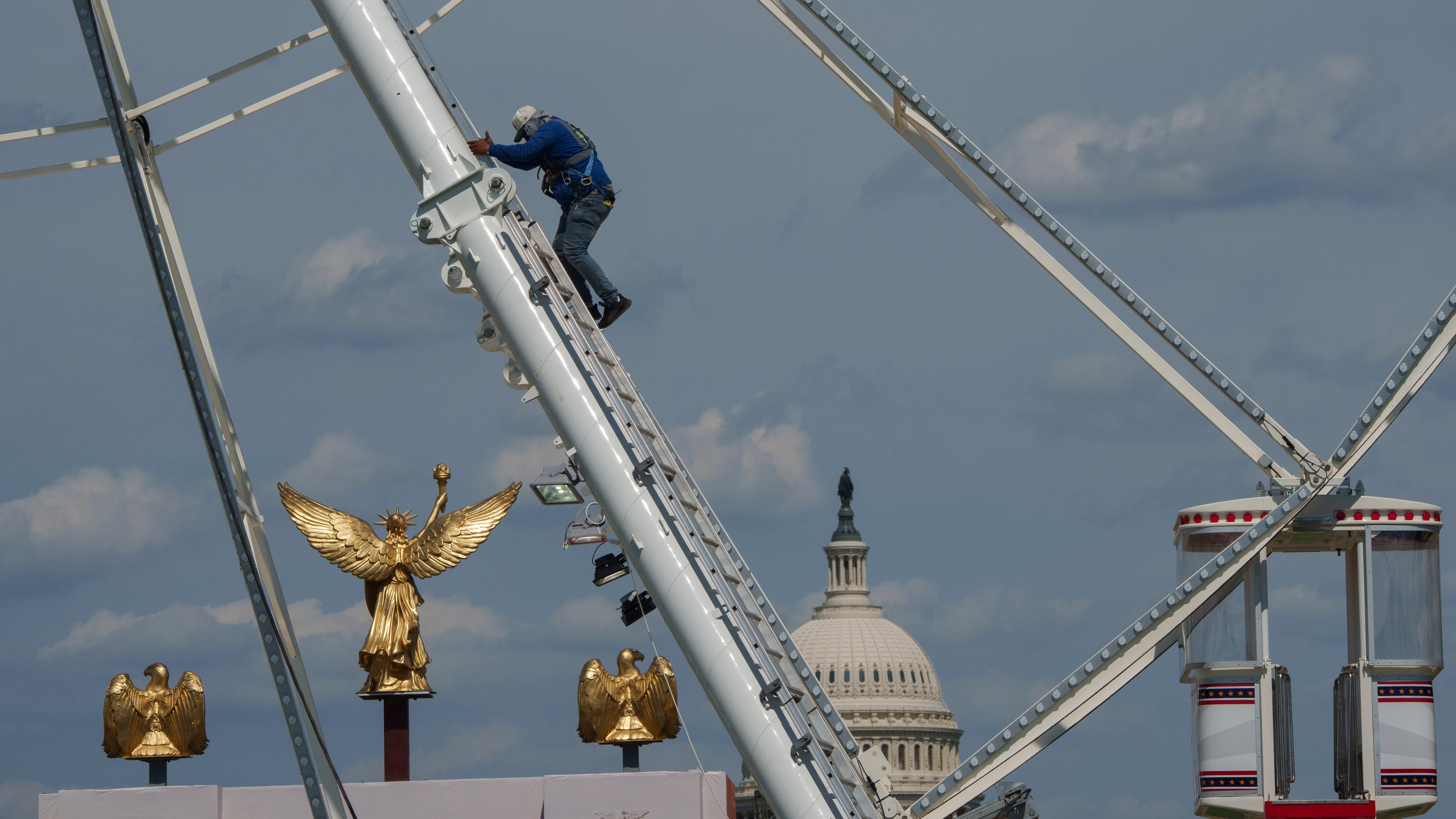 The U.S. Capitol is seen in the background of the ferris wheel as preparation continues for the Great American State Fair on the National Mall, Sunday, June 21, 2026, in Washington. (AP Photo/Jon Elswick