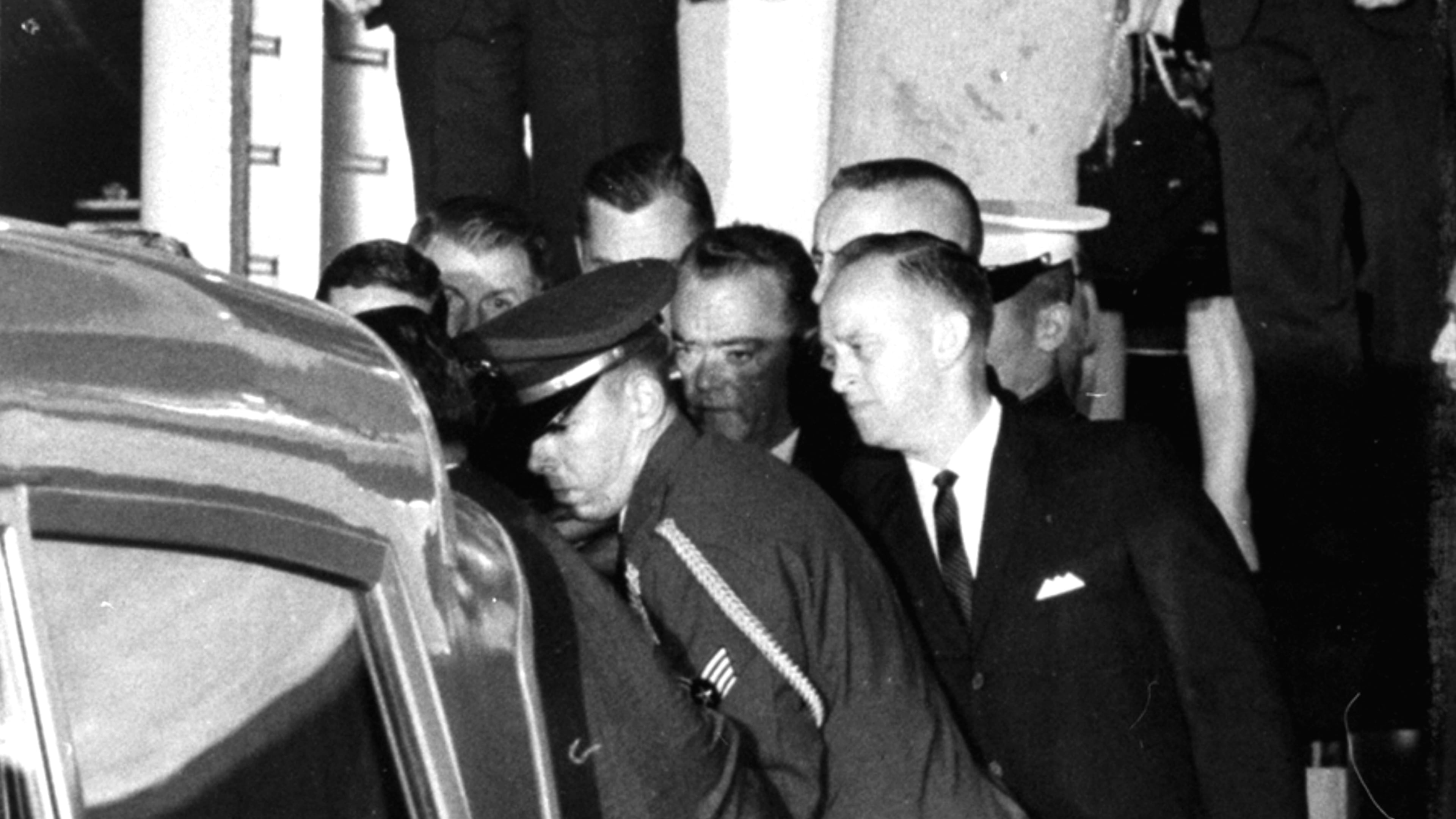 First Lady Jacqueline Kennedy, her dress stained with blood, stands with Attorney Gen.l Robert F. Kennedy, holding her hand, as they watch the casket of her slain husband, President John F. Kennedy, is placed in an ambulance at Andrews Air Force Base, Md., near Washington. The body of the president was flown from Dallas, Texas, where he was fatally shot earlier in the day. At right are Evelyn Lincoln and Kenneth O'Donnell of the White House staff. (AP Photo)
