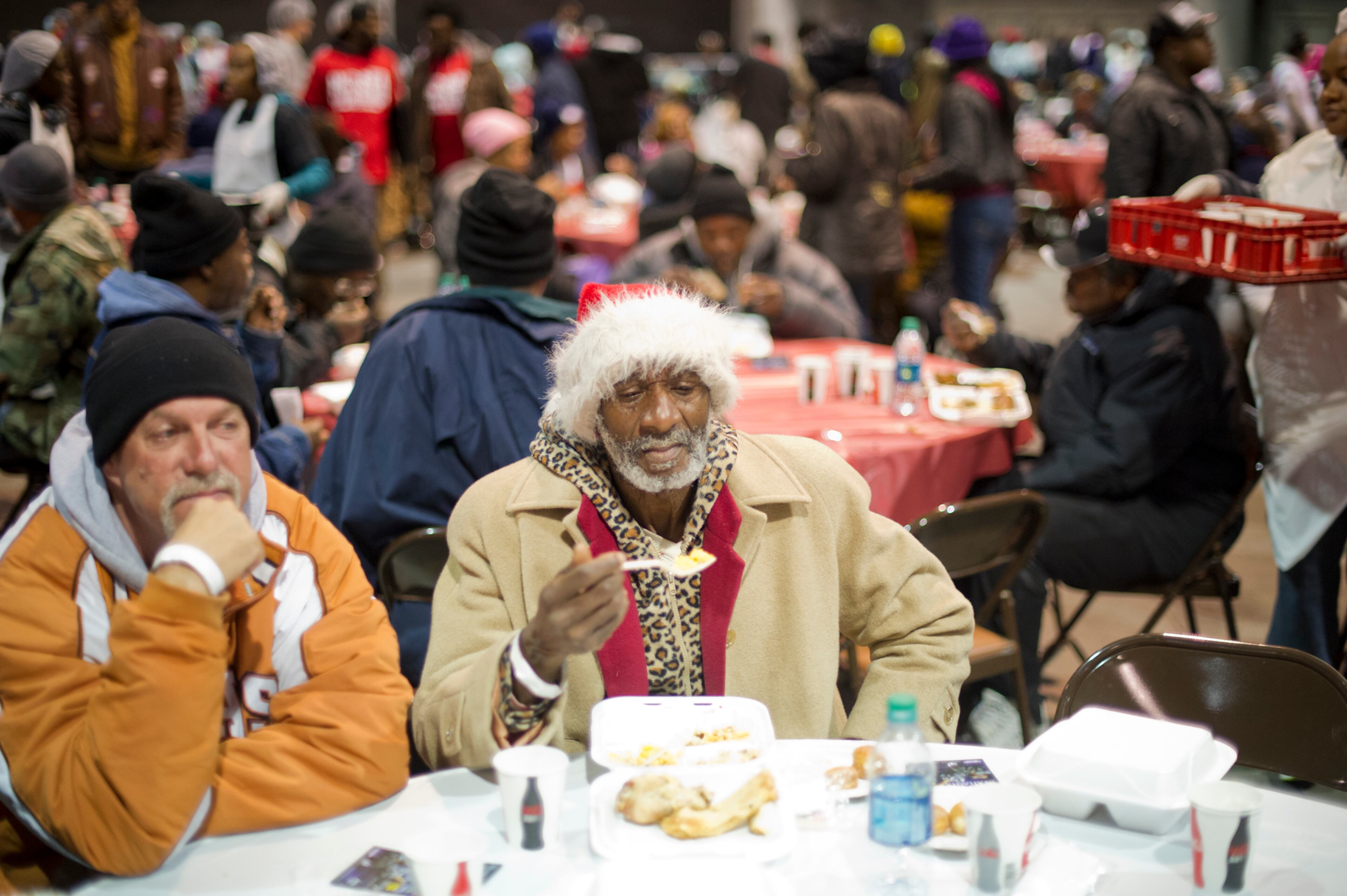 Clarence Miller (center) sits next to Gary Sanders as they eat a five-course Thanksgiving meal during the Hosea Feed the Hungry and Homeless annual Thanksgiving meal at the Georgia World Congress Center in Atlanta on Nov. 28, 2013.