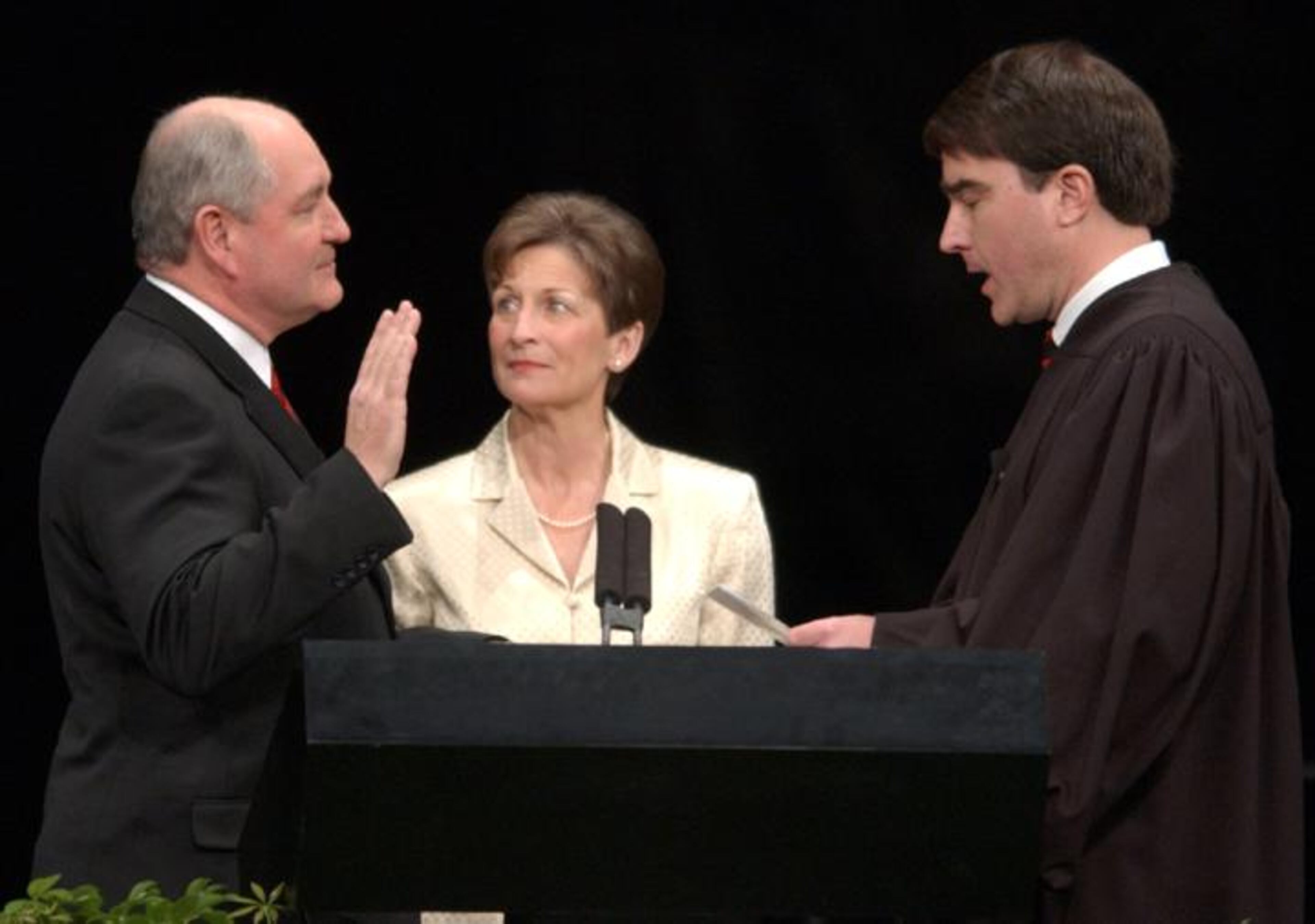 Gov. Sonny Perdue takes the oath of office, administered by the Honorable Clay D. Land (cq), as his wife Mary Perdue (cq) watches him Monday Jan. 13, 2003 in Philips Arena.