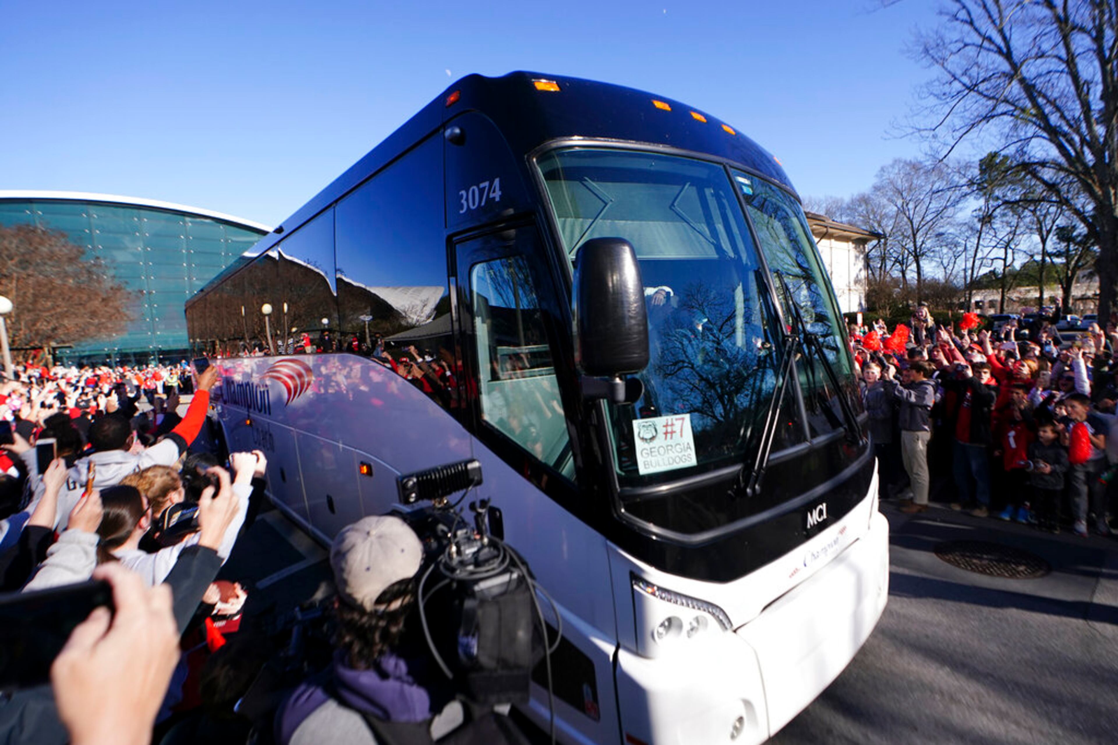 Buses carrying the Georgia football team is greeted by a large crowd of fans as they return to the Georgia campus, Tuesday, Jan. 11, 2022, in Athens, Ga., after defeating Alabama in the College Football Championship NCAA college football game. (AP Photo/John Bazemore)