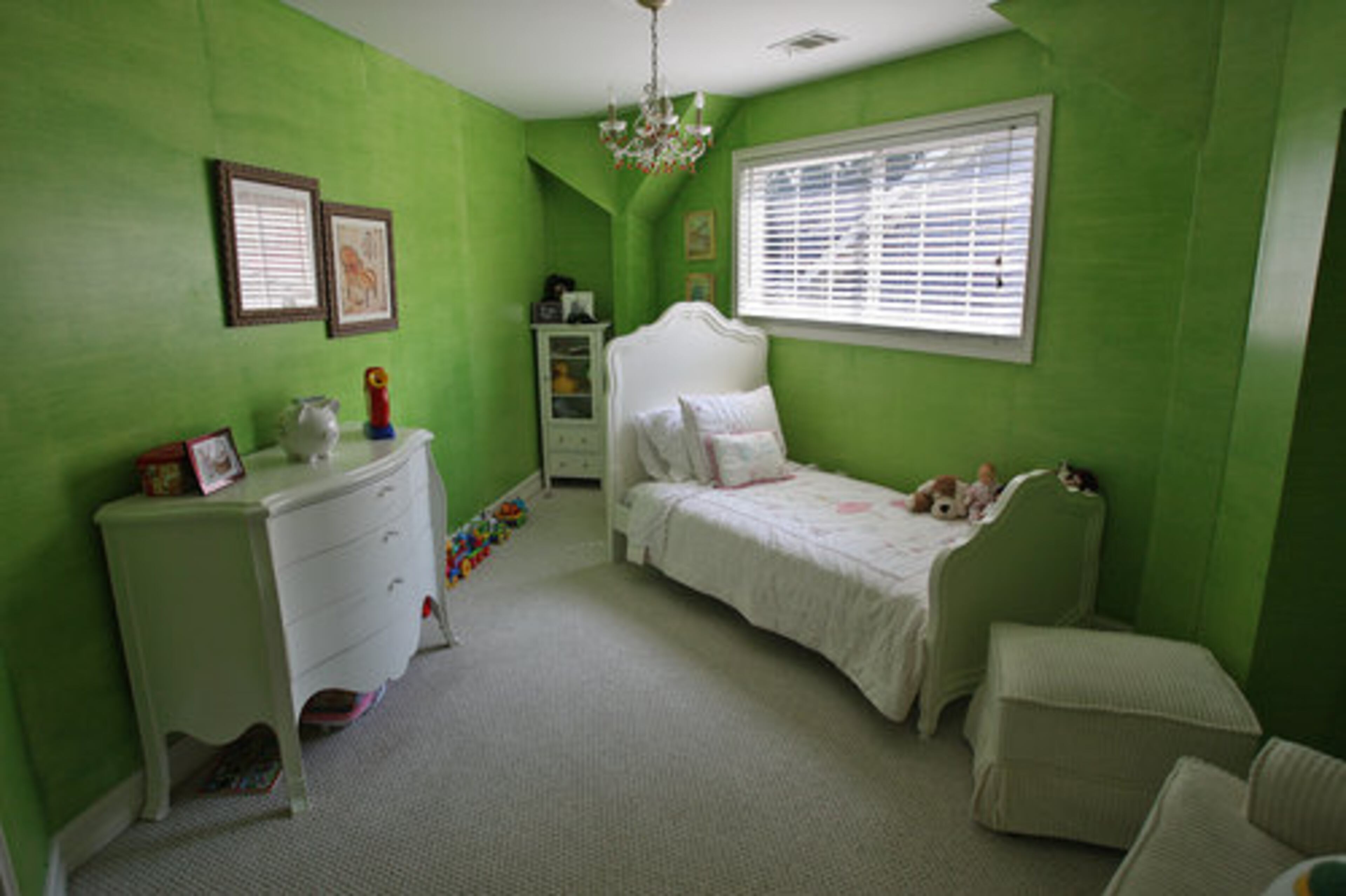 Moving walls in little Olivia's bright green bedroom created nooks for furniture and built-in shelving.