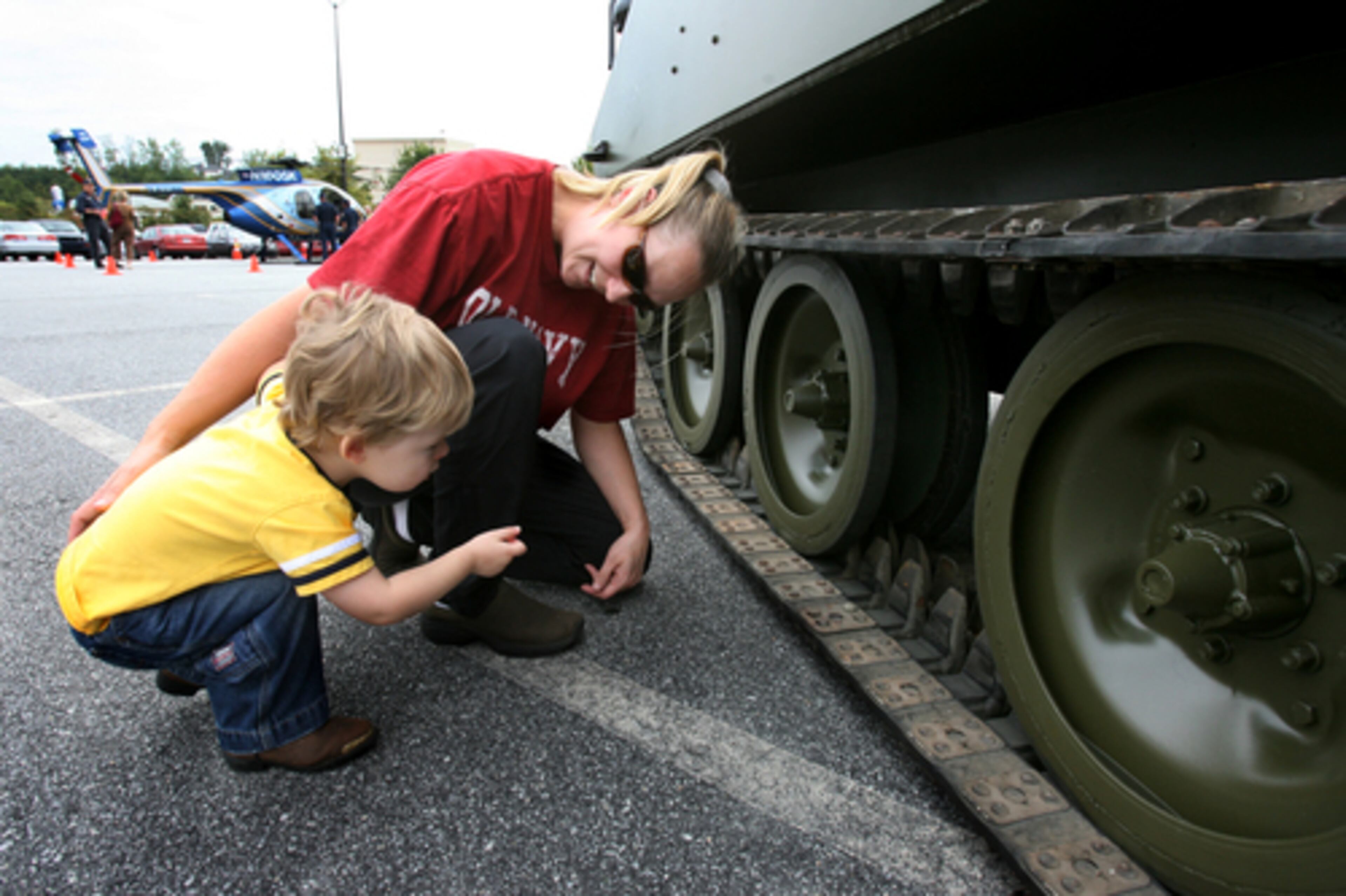 Jesse Drobisch (left) and his mother Jodi Drobisch, of Lawrenvceville, look at the undercarriage of an M-114 armored personnel carrier owned by the Gwinnett County Sheriff's SWAT team. The festival helps to educate the public about law enforcement in Gwinnett County.