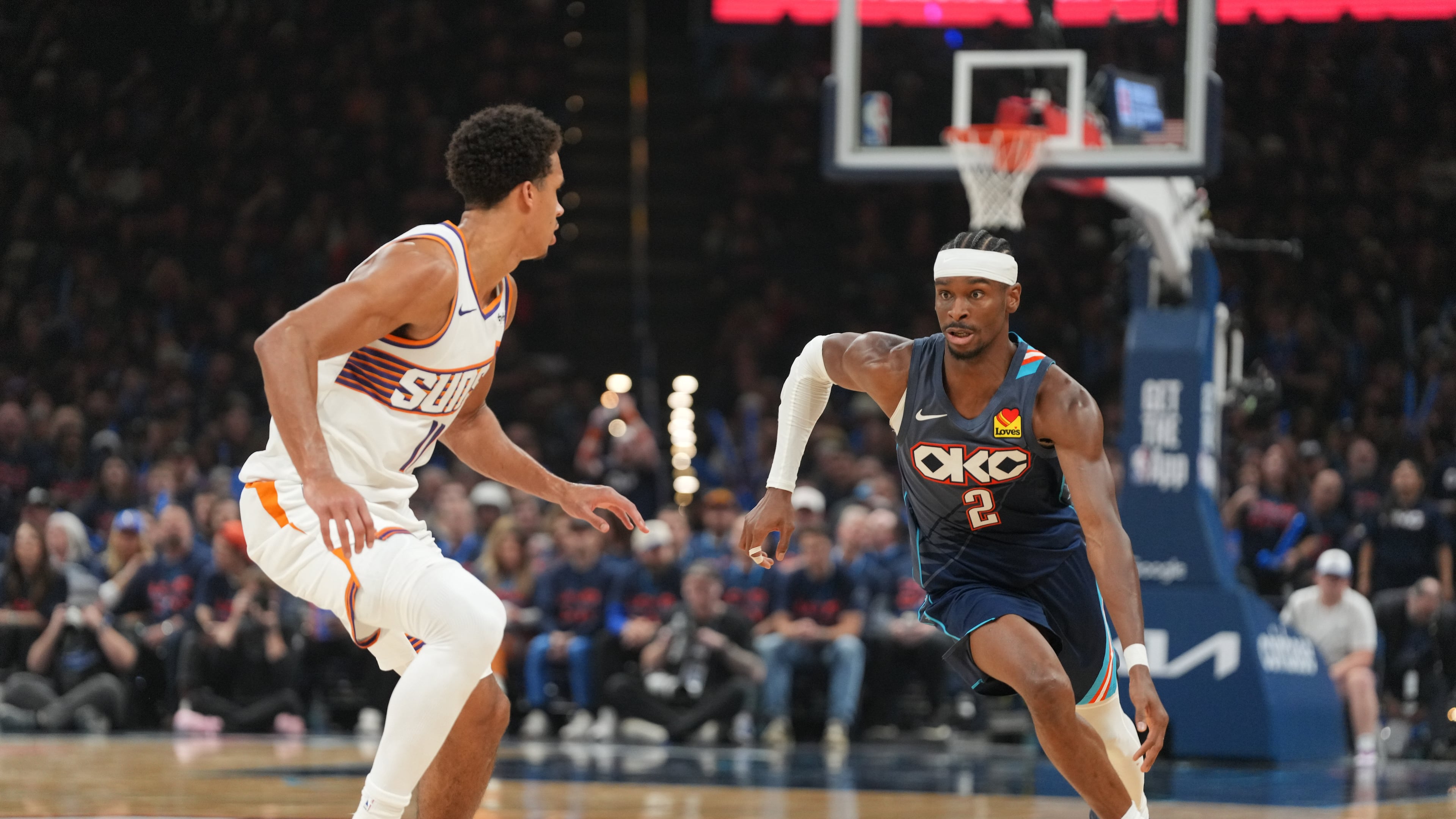 Oklahoma City Thunder guard Shai Gilgeous-Alexander, right, drives past Phoenix Suns forward Oso Ighodaro during the second half in Game 2 of a first-round NBA playoffs basketball series Wednesday, April 22, 2026, in Oklahoma City. (AP Photo/Kyle Phillips)