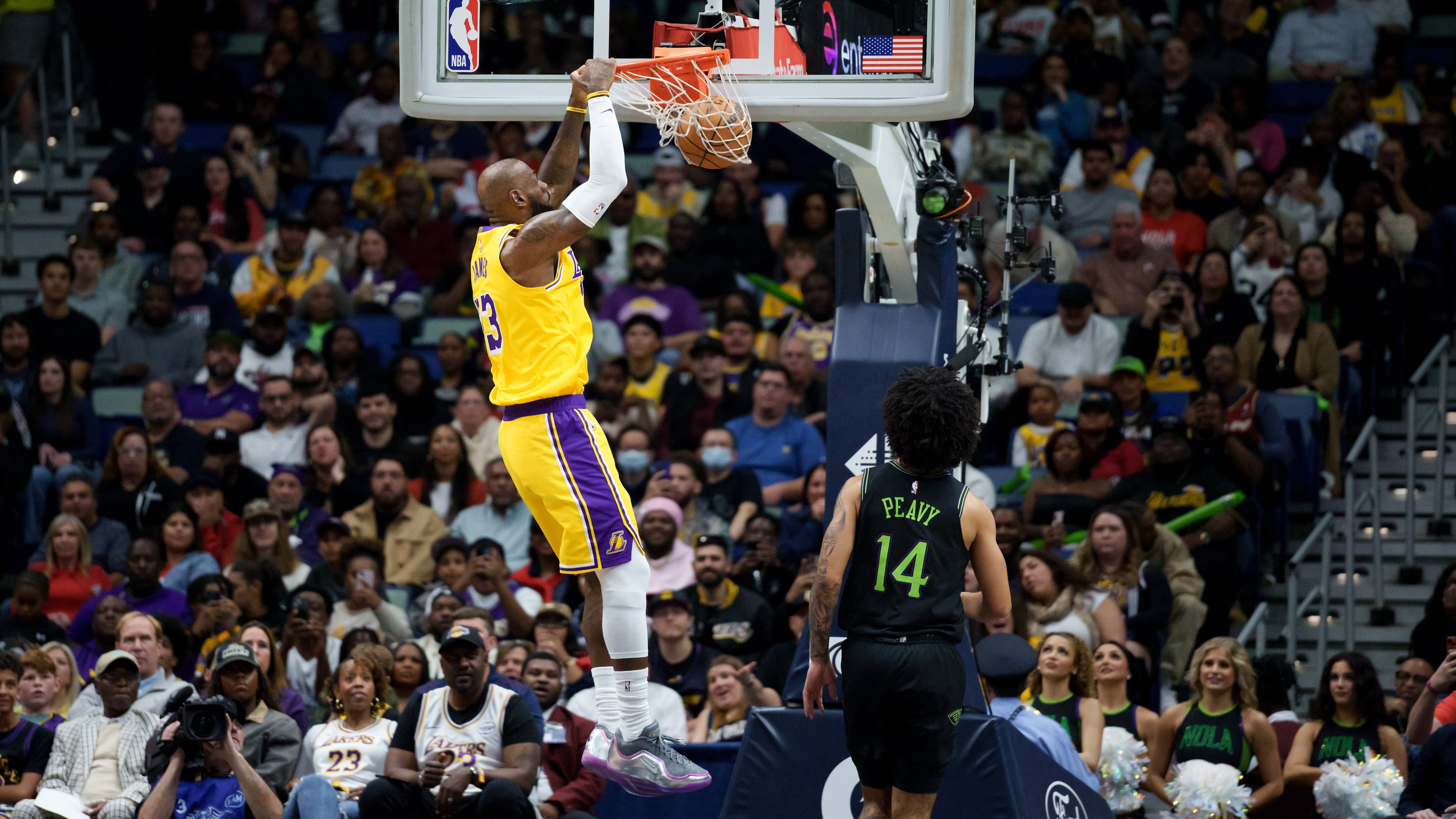 Los Angeles Lakers forward LeBron James (23) dunks next to New Orleans Pelicans guard Micah Peavy (14) during the first half of an NBA basketball game in New Orleans, Tuesday, Jan. 6, 2026. (AP Photo/Matthew Hinton)