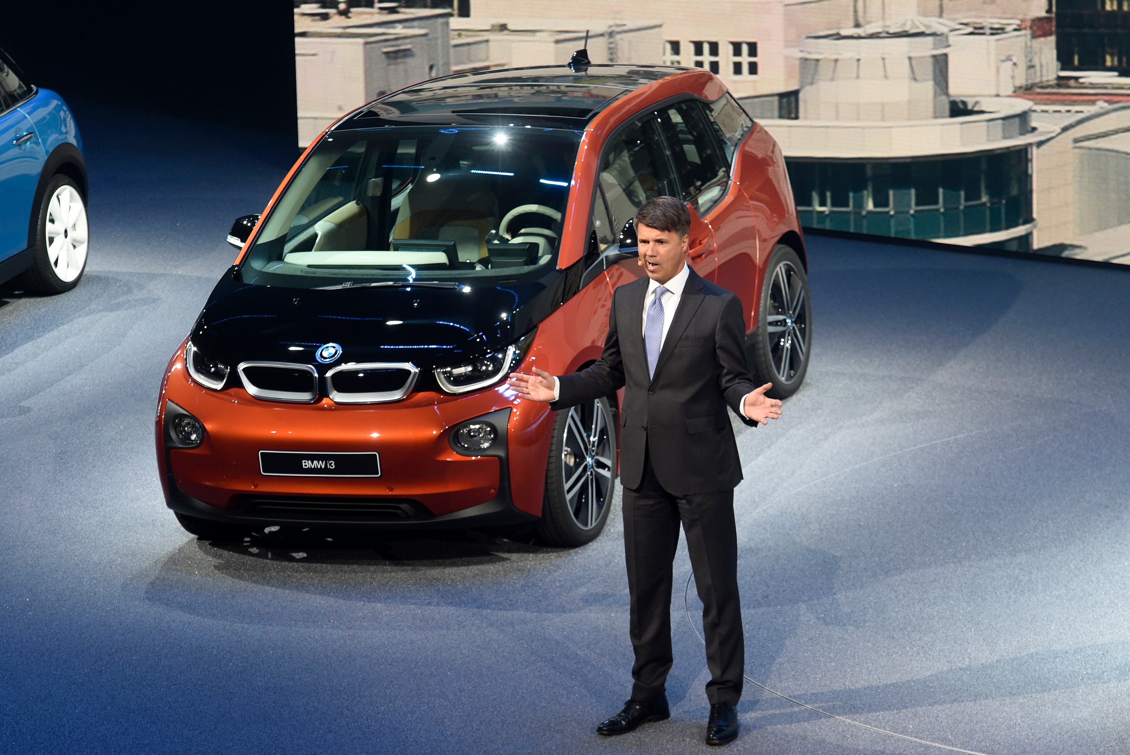 BMW CEO Harald Krueger stands in front of a BMW i3 electric vehicle on the first press day of the Frankfurt Auto Show IAA in Frankfurt, Germany, Tuesday, Sept. 15, 2015. The car show runs through Sept. 27. (AP Photo/Jens Meyer)