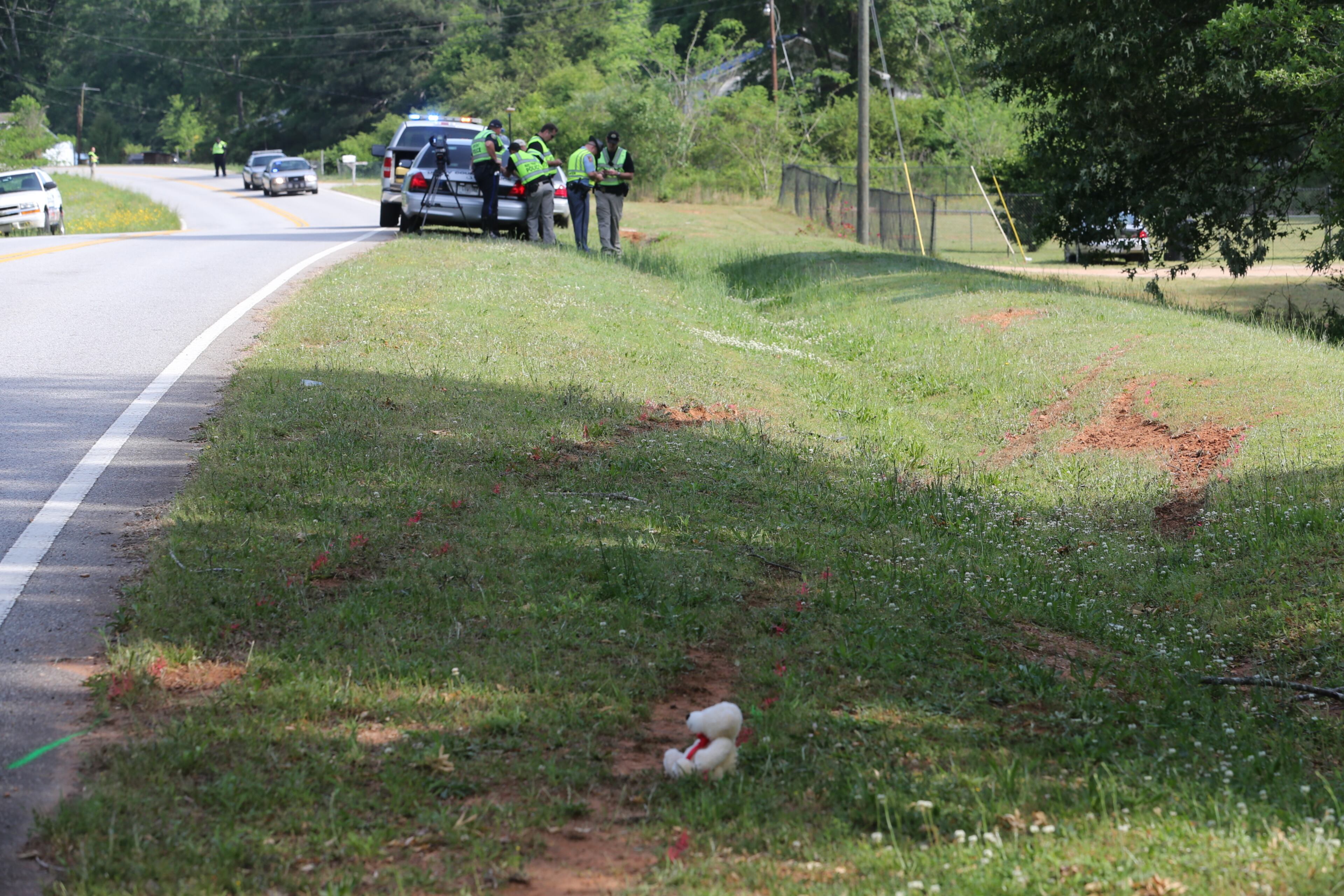 On Thursday morning, a teddy bear sits in memory of a girl, 16, killed in a Henry County accident Wednesday. Two others were injured. In the background, investigators visit the scene of the accident.