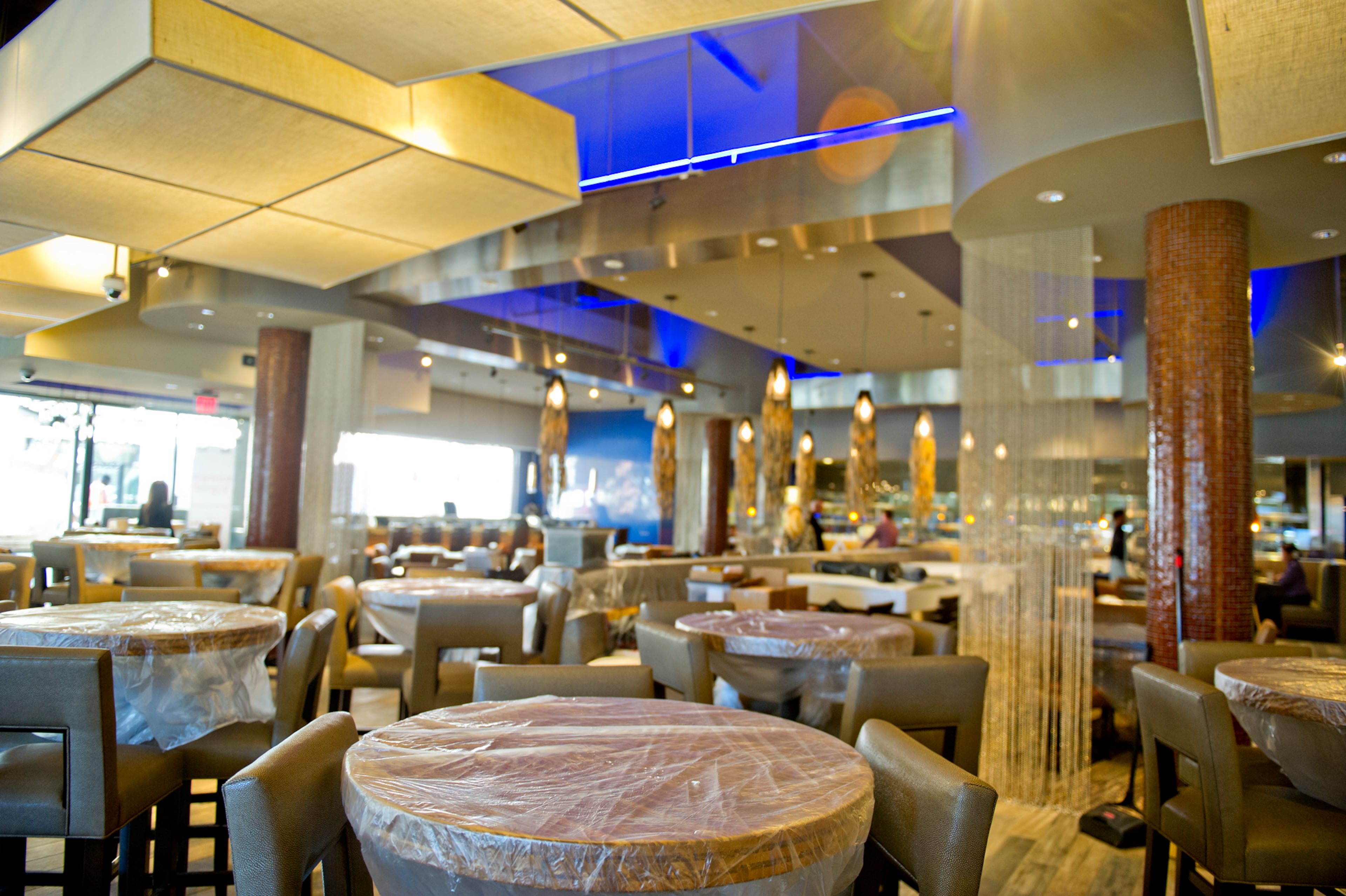 Tables inside the Kona Grill are covered with protective plastic