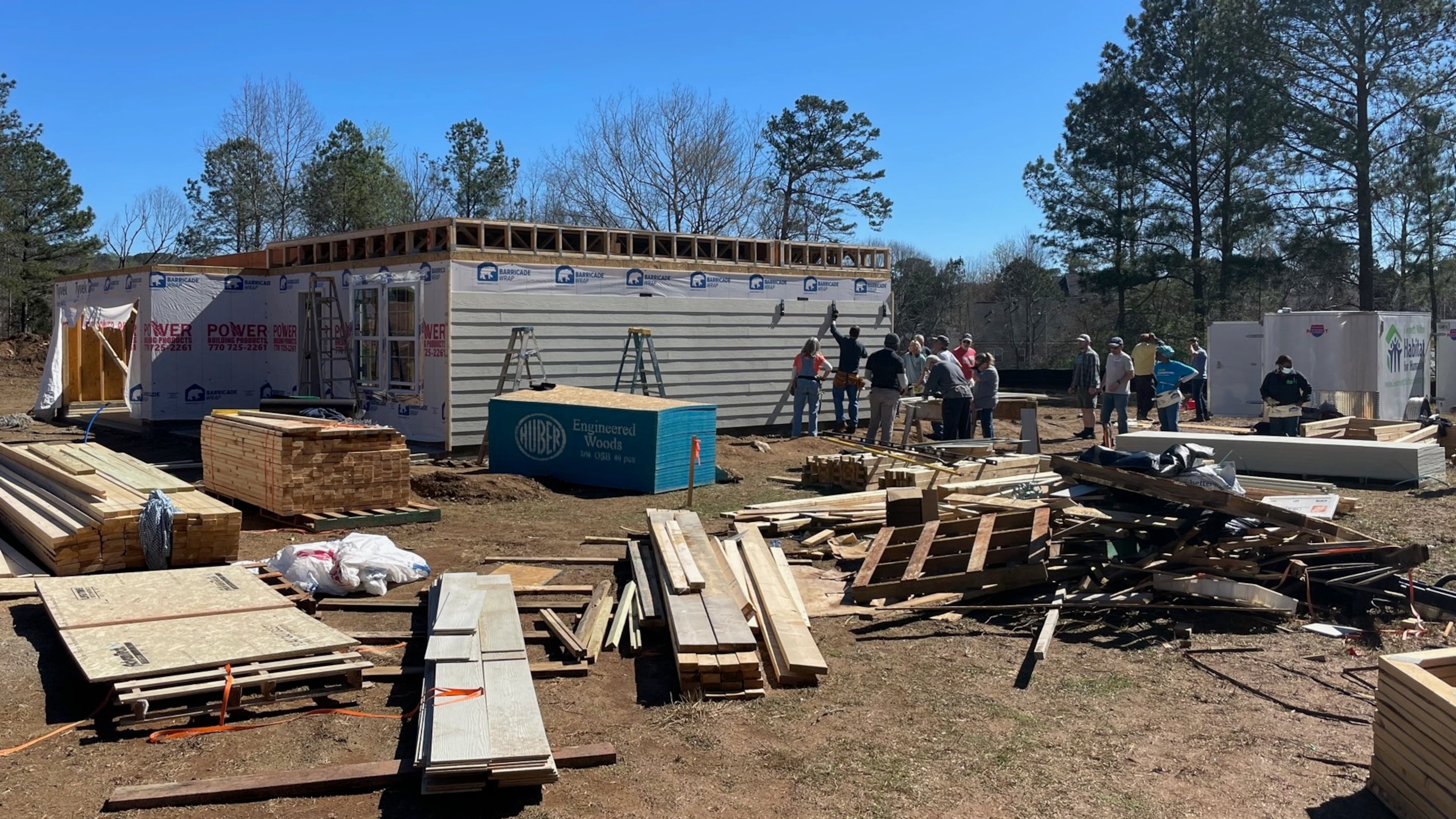 Volunteers from First Baptist Duluth, Christ the King Lutheran and future Habitat for Humanity homeowners work to build one of four houses in Lawrenceville. PHOTO BY KAREN HUPPERTZ FOR THE AJC