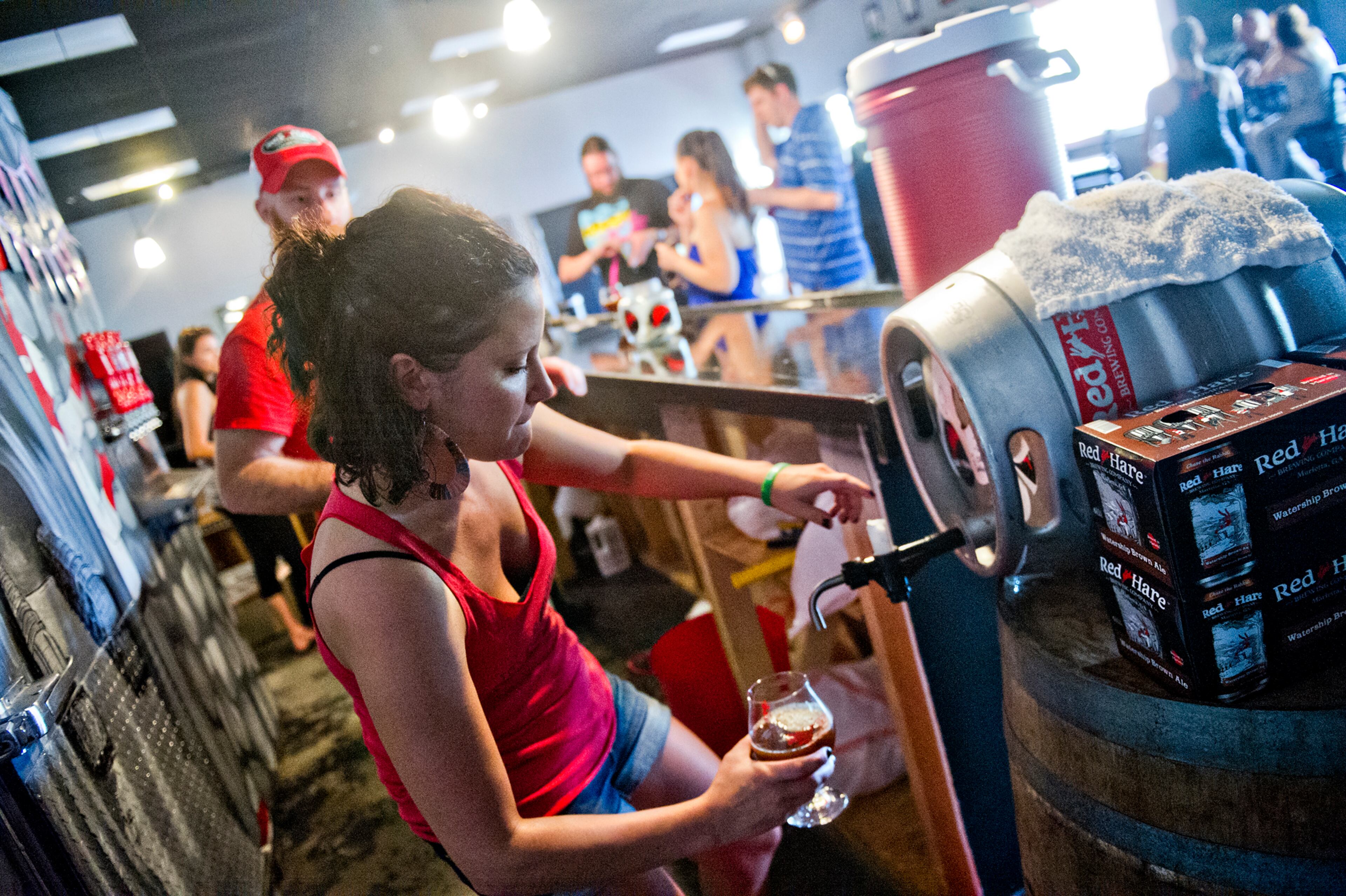 Erica Honeycutt pours beer into a glass at Red Hare Brewery in Marietta during the company's third anniversary party on Saturday, August 23, 2014. JONATHAN PHILLIPS / SPECIAL