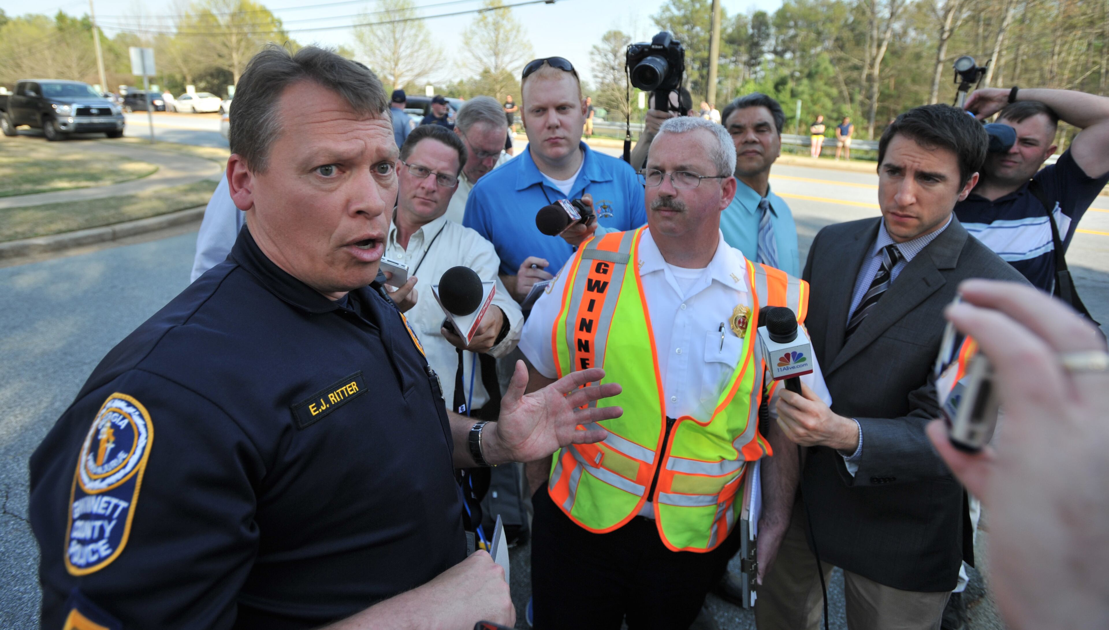 Gwinnett police Cpl. E.J. Ritter speaks to members of the press at the entrance of Walnut Grove at Richland subdivision, across the street from Collins Hill High School in Suwanee.