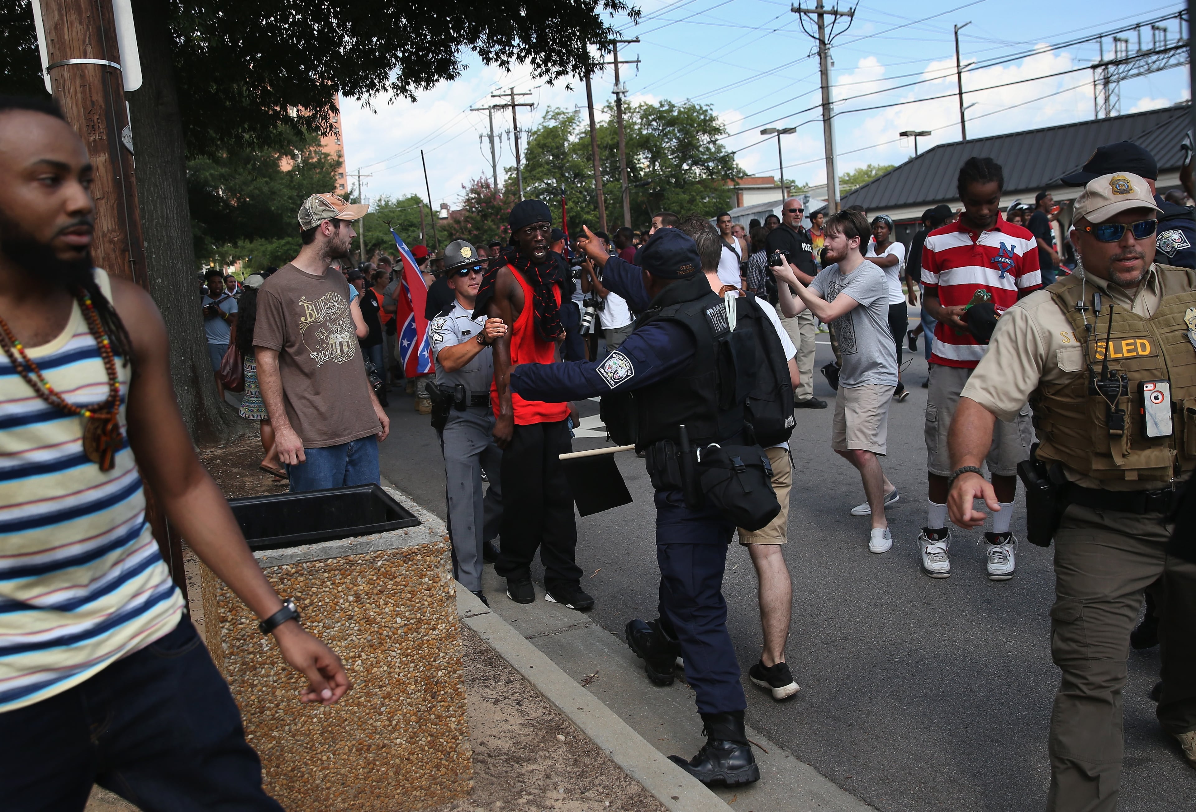 COLUMBIA, SC - JULY 18: Police restrain a counter protesters following a Ku Klux Klan demonstration at the state house building on July 18, 2015 in Columbia, South Carolina. The KKK protested the removal of the Confederate flag from the state house grounds and hurled racial slurs at minorities as law enforcement tried to prevent violence between the opposing groups. (Photo by John Moore/Getty Images)