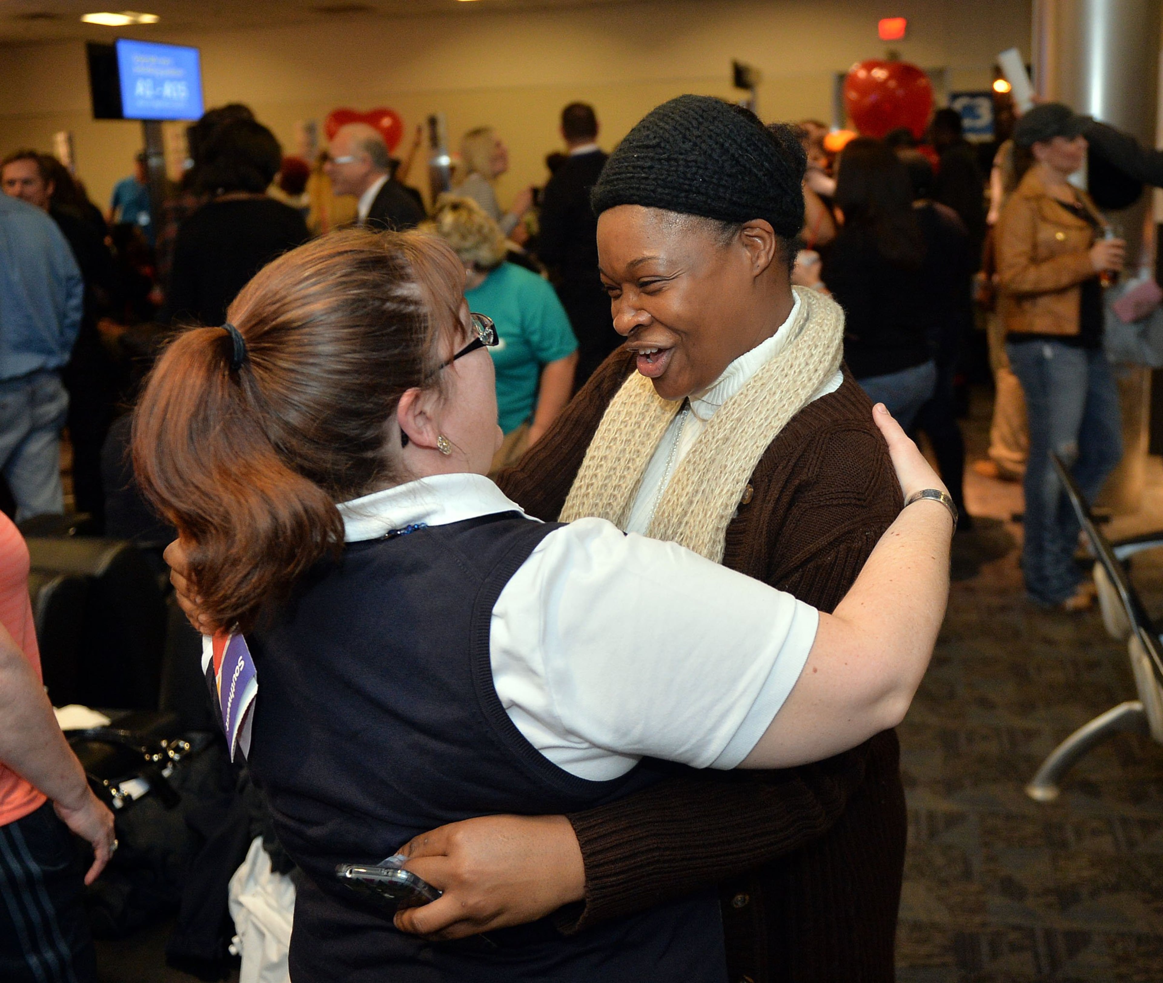 Flight attendants Karen Mowrey (left) and Jozette Brown hug during the celebration. Hundreds of Southwest Airlines and former AirTran Airways employees gathered at Concourse C, gates 1, 2 and 3 to celebrate the departure of AirTran’s final flight to Tampa, at Hartsfield-Jackson International Airport, Sunday, December 28, 2014. Southwest CEO Gary Kelly and executives Bob Jordan and Jack Smith gave remarks during the program. The full flight was waved off by employees that gathered on the tarmac as crash trucks from Atlanta Fire Rescue gave a final water cannon salute as the plane departed. KENT D. JOHNSON/KDJOHNSON@AJC.COM